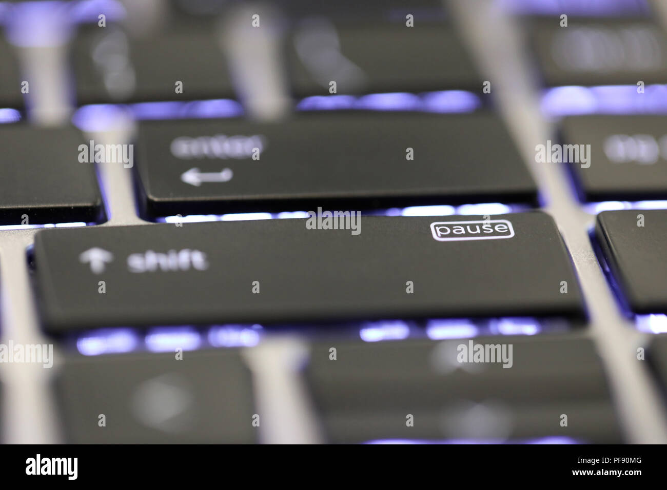 Chiusura del tasto pausa simbolo del pulsante carattere speciale su una tastiera illuminata su un computer portatile o un computer. Foto Stock