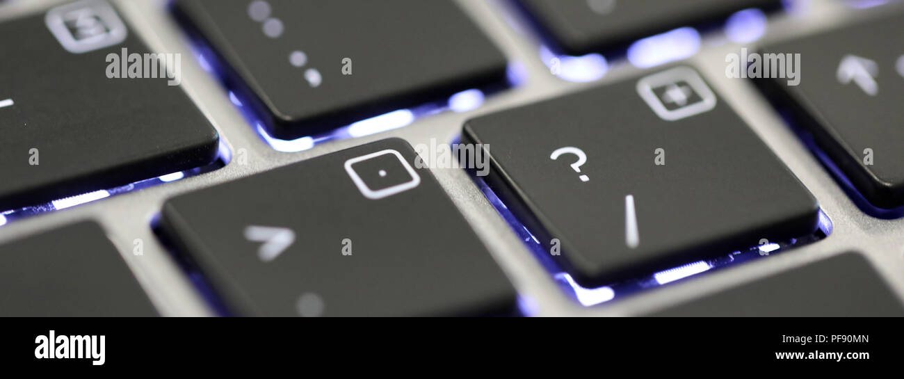 Close up il simbolo del punto interrogativo carattere speciale su una tastiera illuminata su un computer portatile o un computer. Foto Stock