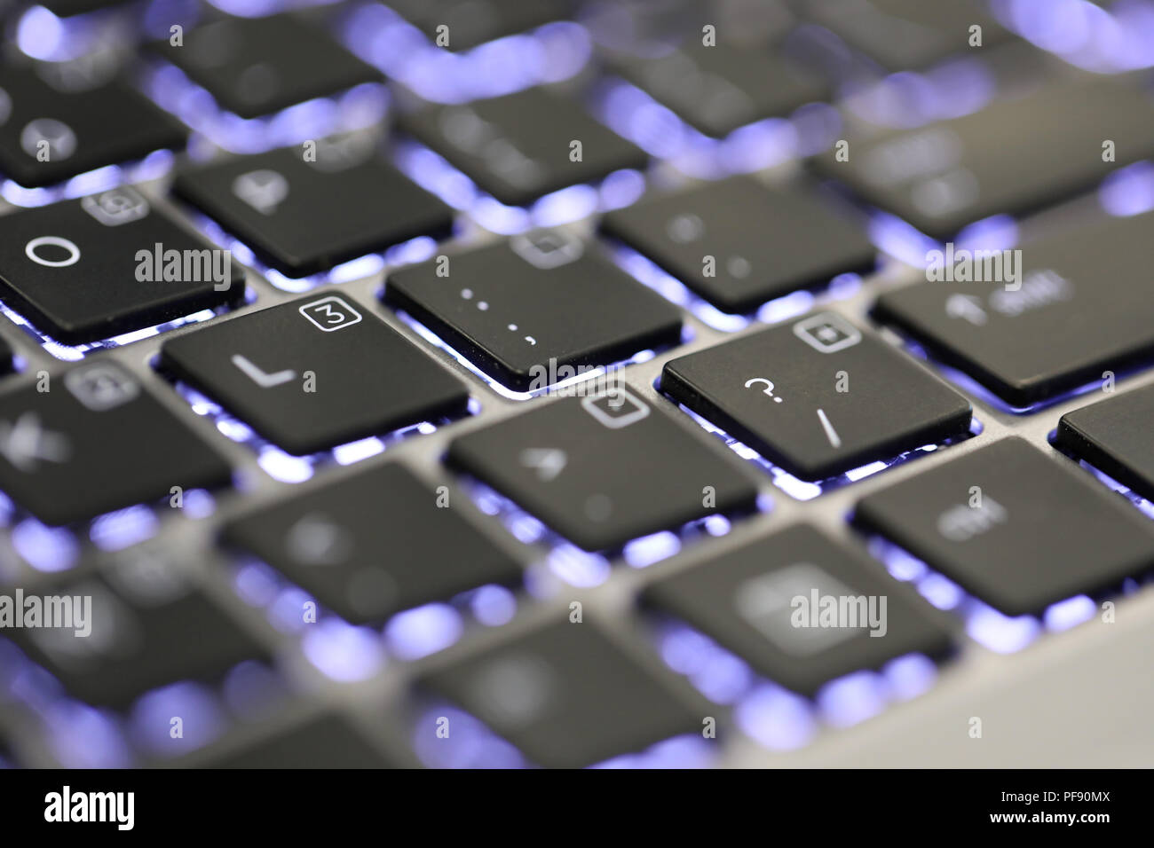 Close up il simbolo del punto interrogativo carattere speciale su una tastiera illuminata su un computer portatile o un computer. Foto Stock