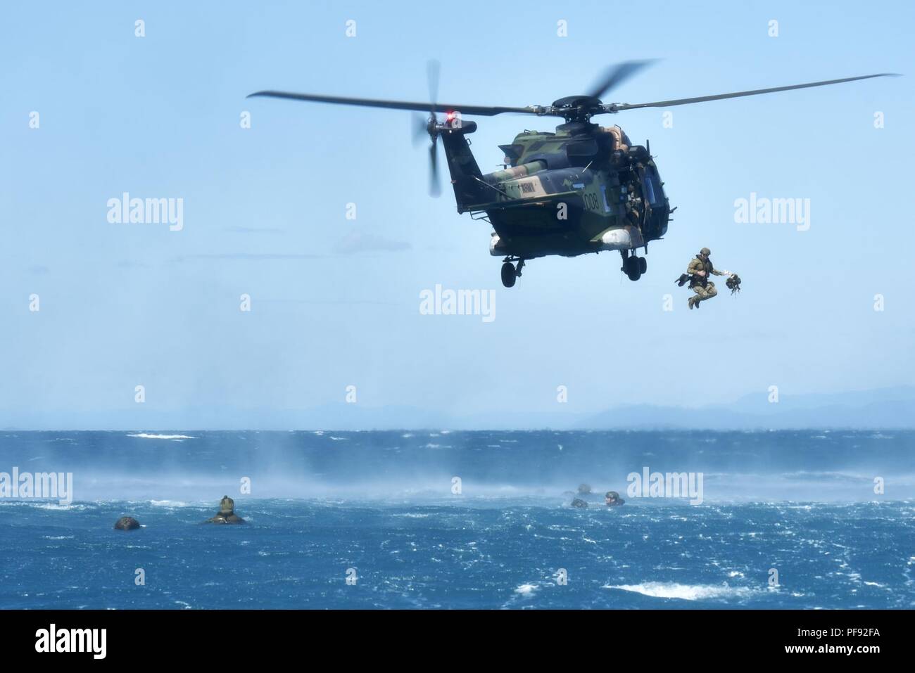 Membri della Australian Defence Force partecipare helocasting saltando fuori un MRH-90 al largo delle coste orientali dalla Australia 7 Giugno. Il servizio membri sono attualmente intrapreso la HMAS Canberra nel supporto di esercizio mare serie 18. Stati Uniti Marines e Navy corpsmen con Marine forza rotazionale - Darwin sono anche partecipanti in mare le operazioni di serie. Foto Stock