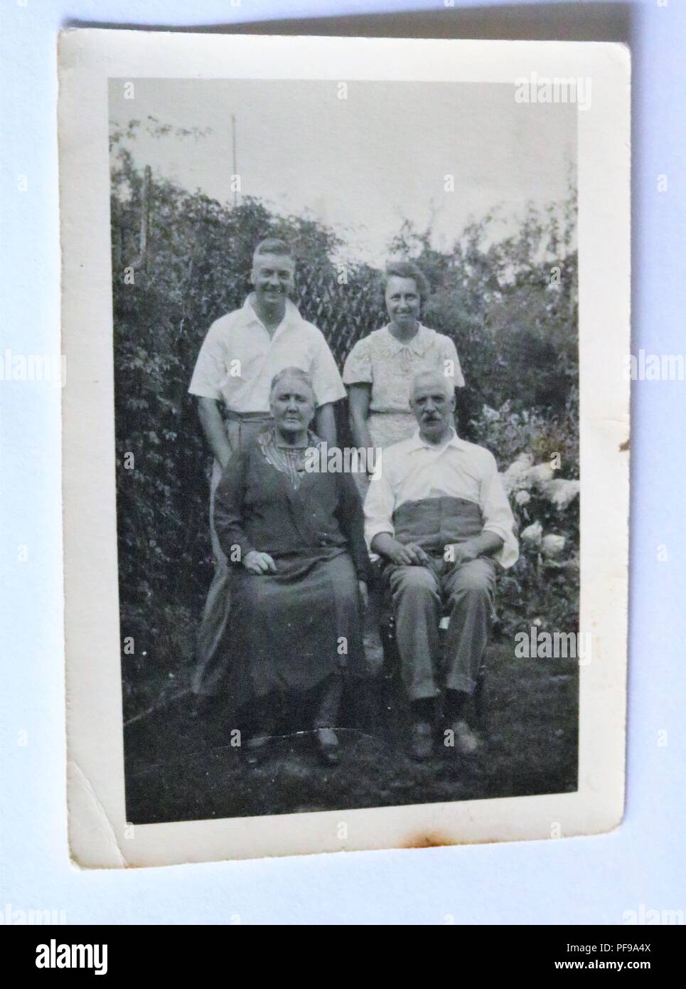 Storia sociale - bianco e nero vecchia fotografia che mostra quattro persone di mezza età di persone in un giardino Foto Stock