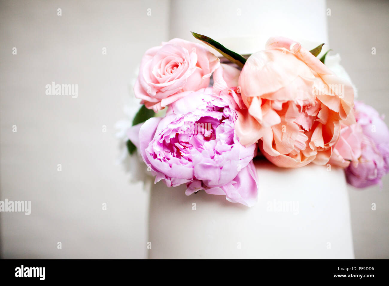 Vista dettagliata del moderno e bianco torta di nozze con peonia peonie decorazione e lo spazio negativo Foto Stock
