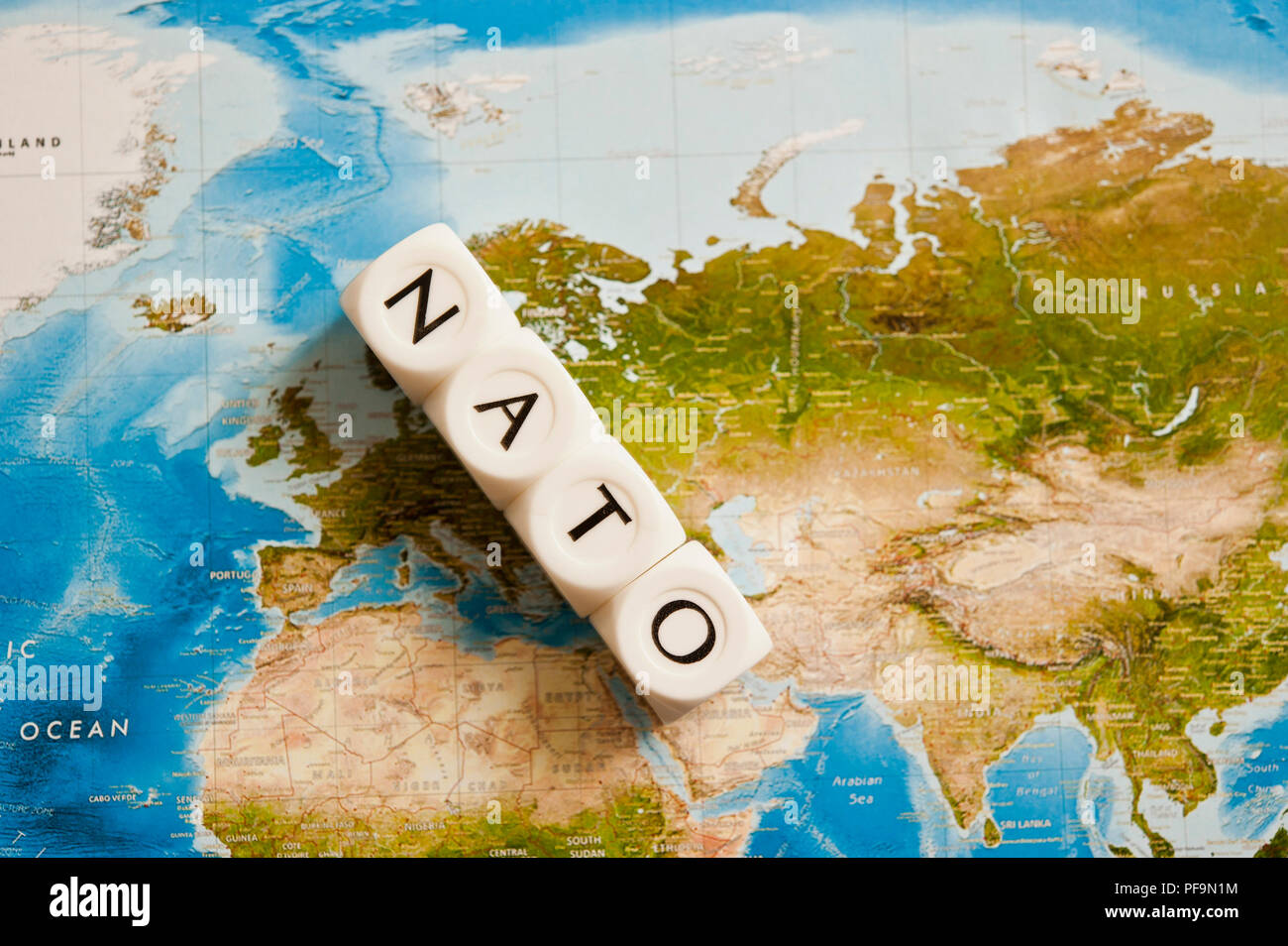 La NATO scritto con dadi su una mappa del mondo, concetto per l'Organizzazione del Trattato del Nord Atlantico espandendo i suoi membri Foto Stock