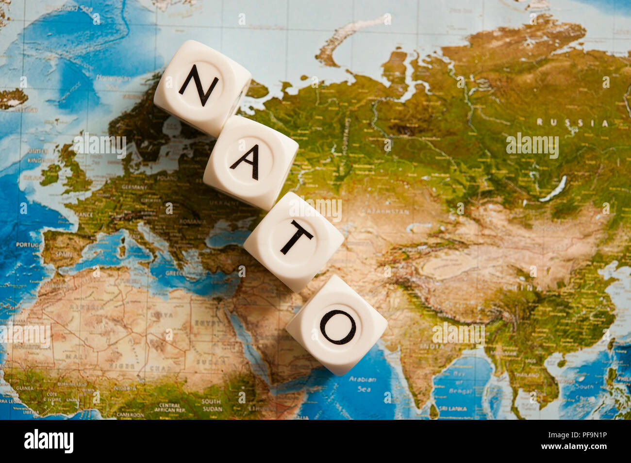 La NATO scritto con dadi su una mappa del mondo, concetto per l'Organizzazione del Trattato del Nord Atlantico espandendo i suoi membri Foto Stock