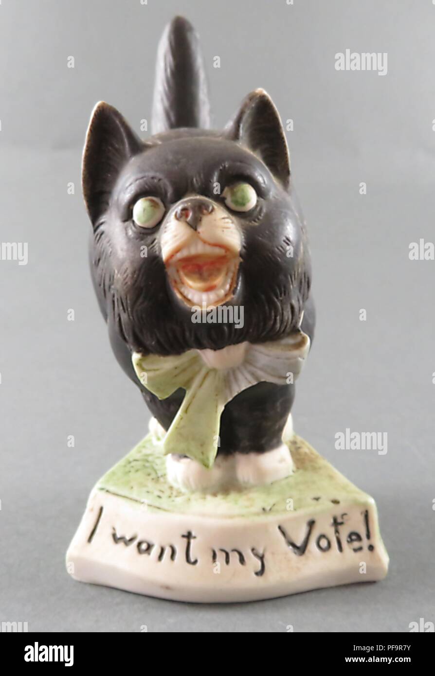 Statuetta in ceramica raffigurante un gatto nero come un suffragette, con una verde e viola arco in corrispondenza di un suo collare, una seria di espressione sul suo volto, aprire bocca, occhi grandi, coda rigida e una didascalia alla base la lettura "Voglio che il mio voto", prodotta dalla ditta tedesca di Schafer e Vater sia per i britannici e i mercati americani, 1900. () Foto Stock