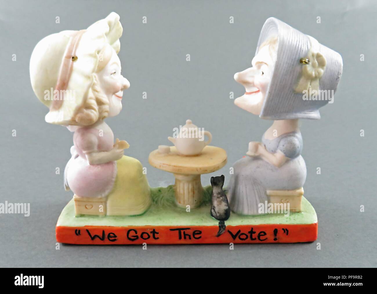 Ceramica,"bobble-head' o testa mobile statuetta raffigurante due donne in Edwardian abiti, sia che indossa berretti, seduto di fronte a ogni altro a un tavolo gustando il tè con una didascalia sulla base lettura "abbiamo avuto il diritto di voto", prodotta dalla ditta tedesca Schafer e Vater per entrambi i mercati americano e britannico, 1900. () Foto Stock