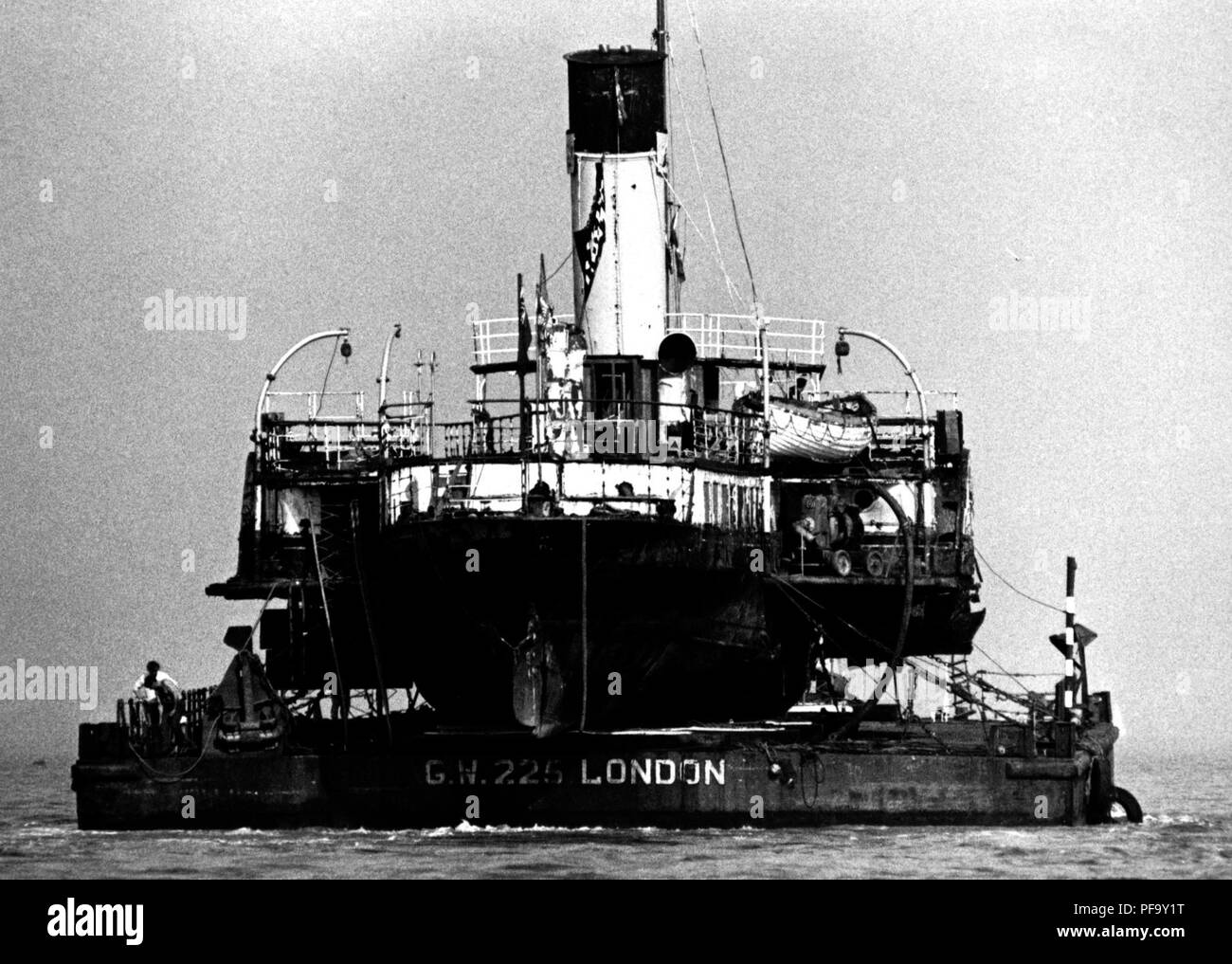 AJAXNETPHOTO. 20Aprile, 1984. COWES, Isola di Wight in Inghilterra. - La regina ottiene un ascensore - IL BATTELLO A VAPORE MEDWAY REGINA caricato su un pontone, trainato fuori del fiume MEDINA in rotta per il Tamigi. Foto:JONATHAN EASTLAND/AJAX REF:842004 1 Foto Stock