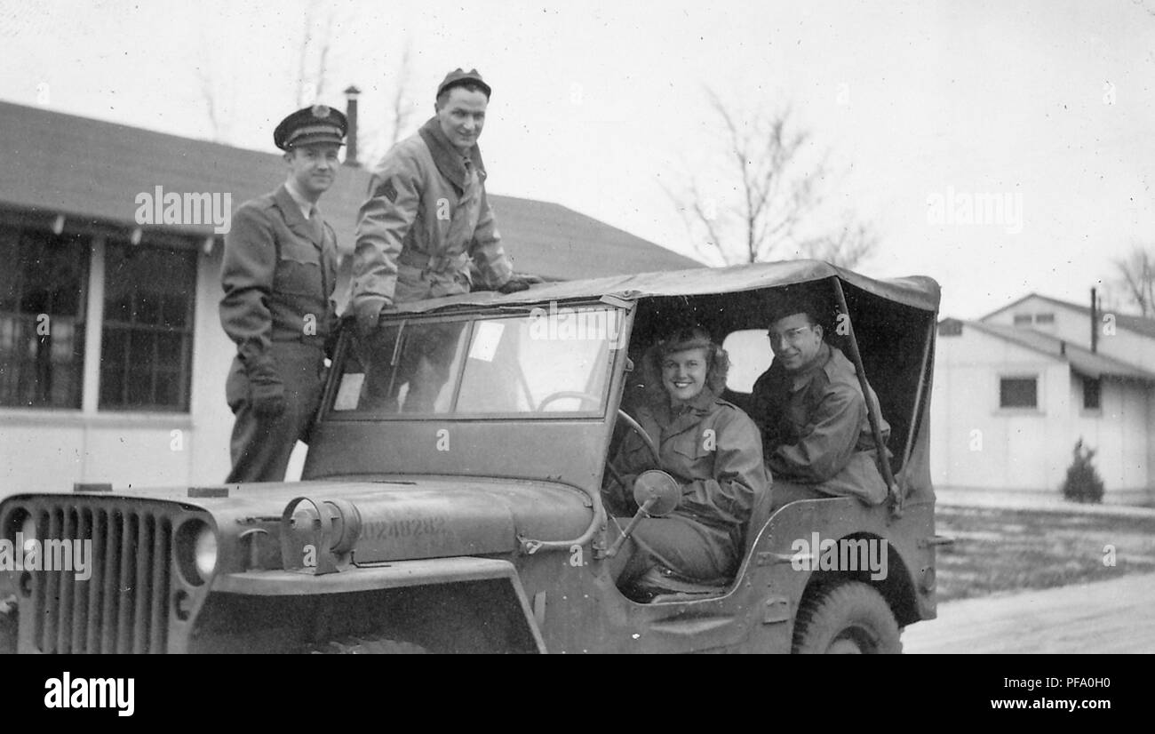 Fotografia in bianco e nero, mostrando diversi militari seduta all'interno di un veicolo militare e in piedi sulla pedana, compreso un giovane e sorridente, driver femminile, e tre uomini con tutti e quattro i vestiti in uniformi militari, probabilmente fotografato in Ohio durante la II Guerra Mondiale, 1945. () Foto Stock