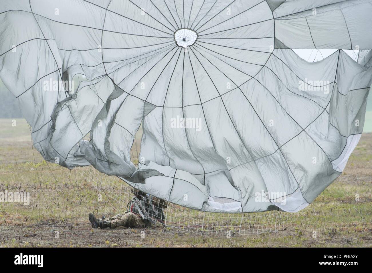 Un aviatore assegnati al 3° aria supportano operazioni Squadron atterra su Malemute Drop Zone dopo il salto da un esercito di Alaska National Guard UH-60 Black Hawk elicottero durante il volo in formazione di base comune Elmendorf-Richardson, Alaska, 30 maggio 2018. Avieri dal 3° ASOS, Soldati assegnati a U.S. Esercito Alaska e Alaska esercito nazionale Guard aviatori con il primo battaglione, 207th reggimento di aviazione, condotto la joint airborne jump training per aumentare l'interoperabilità e mantenere la disponibilità di missione. Foto Stock