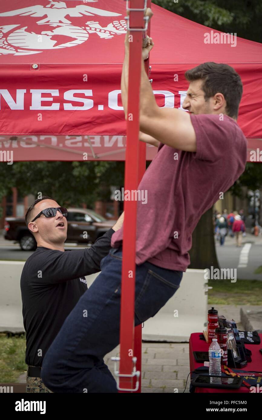 PORTLAND, Ore. (Giugno 8, 2018) personale marino Sgt. Trey Renuard, comandante della stazione, stazione di reclutamento di Portland, orologi come Matt Haight, nativo di Chicago, tenta il Marine Corps pull-up sfida durante il Portland Rose Festival Settimana della flotta. Il festival e Portland Settimana della flotta sono una festa del mare servizi con i marinai, marine, e Guardia Costiera membri provenienti da Stati Uniti e Canada che rendono la città una porta di chiamata. Foto Stock