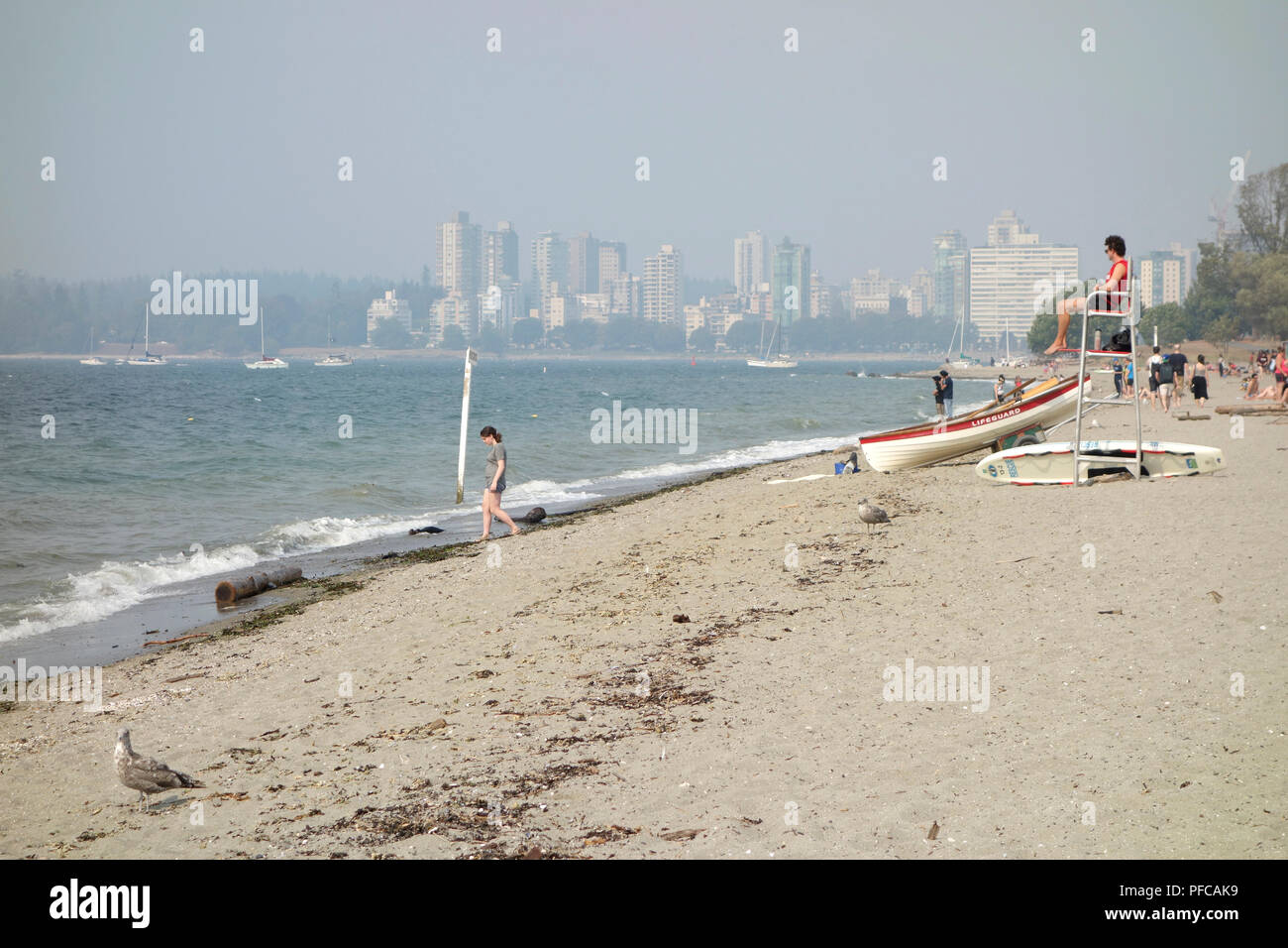 Vancouver, BC, Canada. 20 agosto 2018. Fumo denso da incendi in provincia copre Vancouver lunedì, come visto dalla Kitsilano Beach in English Bay. Il highrises del West End e le foreste del Parco di Stanley sono a malapena visibili attraverso il fumo e le montagne in distanza sono completamente oscurati. La qualità dell'aria è molto scarsa e un advisory è in effetto. Foto Stock