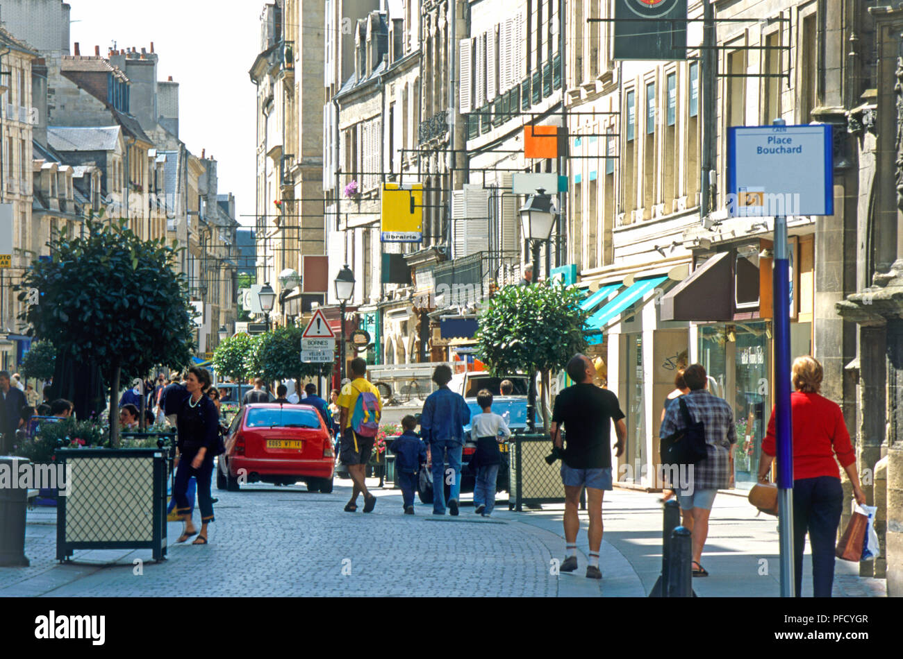 Francia, Normandia, Caen, Rue St Pierre, il traffico e i pedoni sulla strada costeggiata da negozi Foto Stock