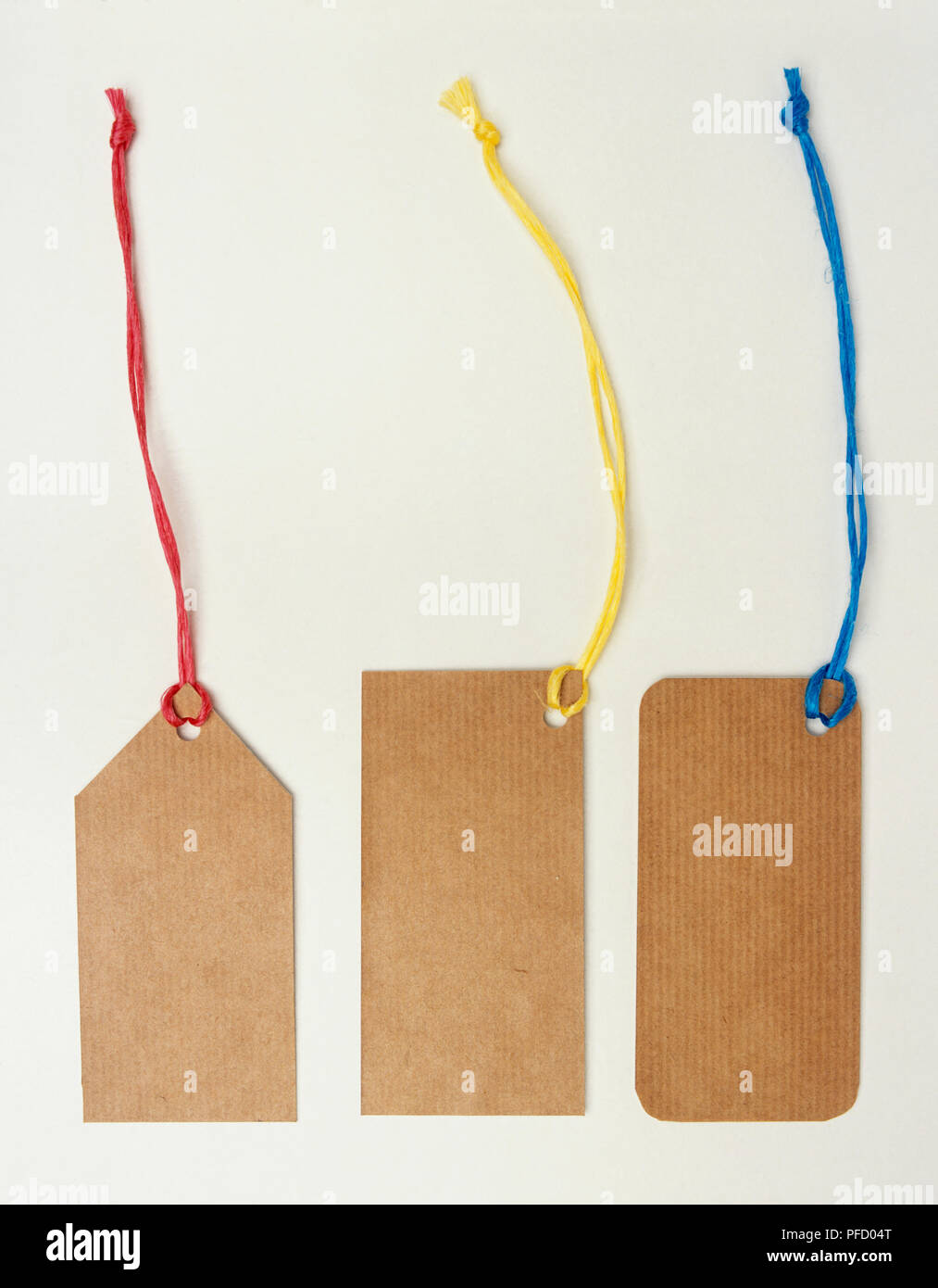 Tre etichette di cartone legata a stringhe colorate, close up Foto Stock