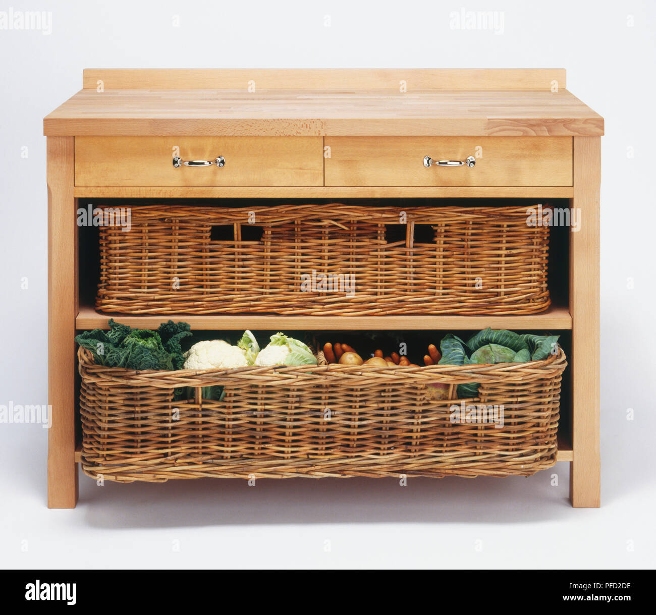 Un armadio contenente cestini di vimini pieno di verdure Foto Stock