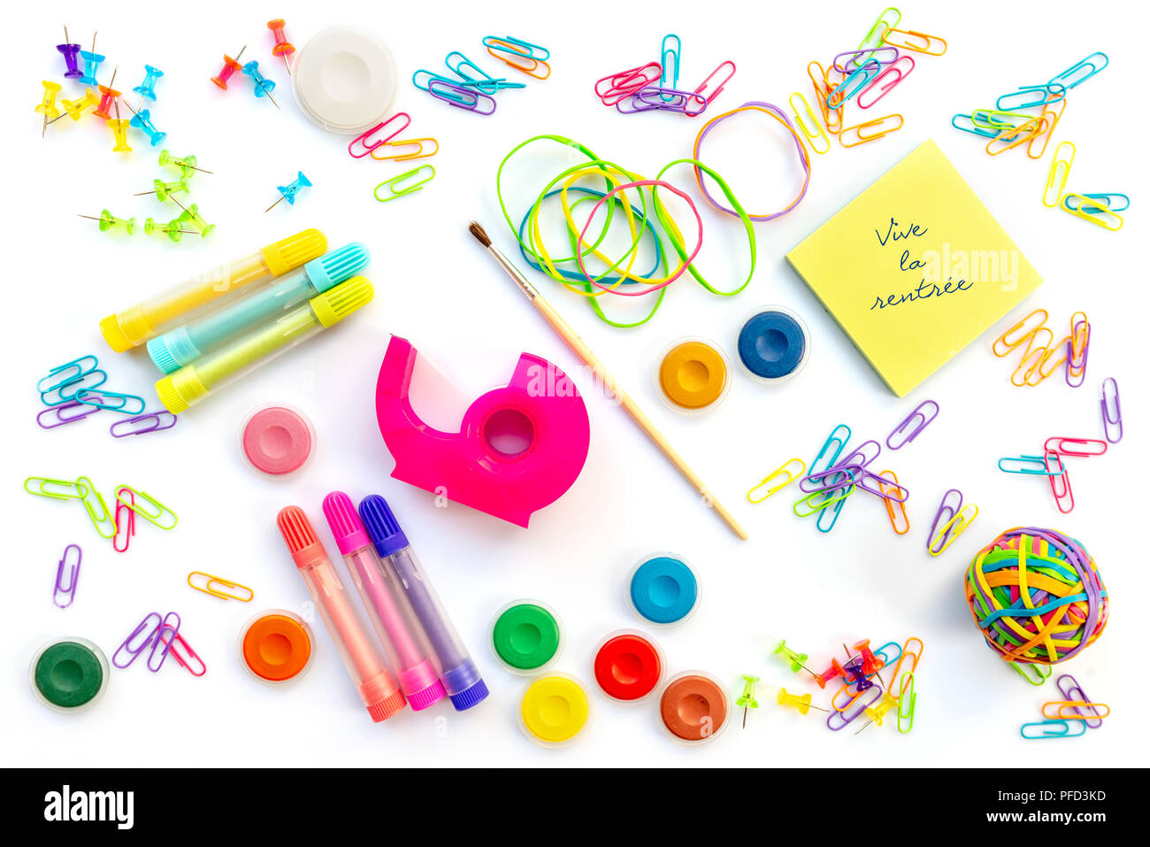 Vive la rentree (significato il ritorno a scuola in francese) scritto su foglietti adesivi tra colorate di forniture scolastiche isolati su sfondo bianco. Foto Stock