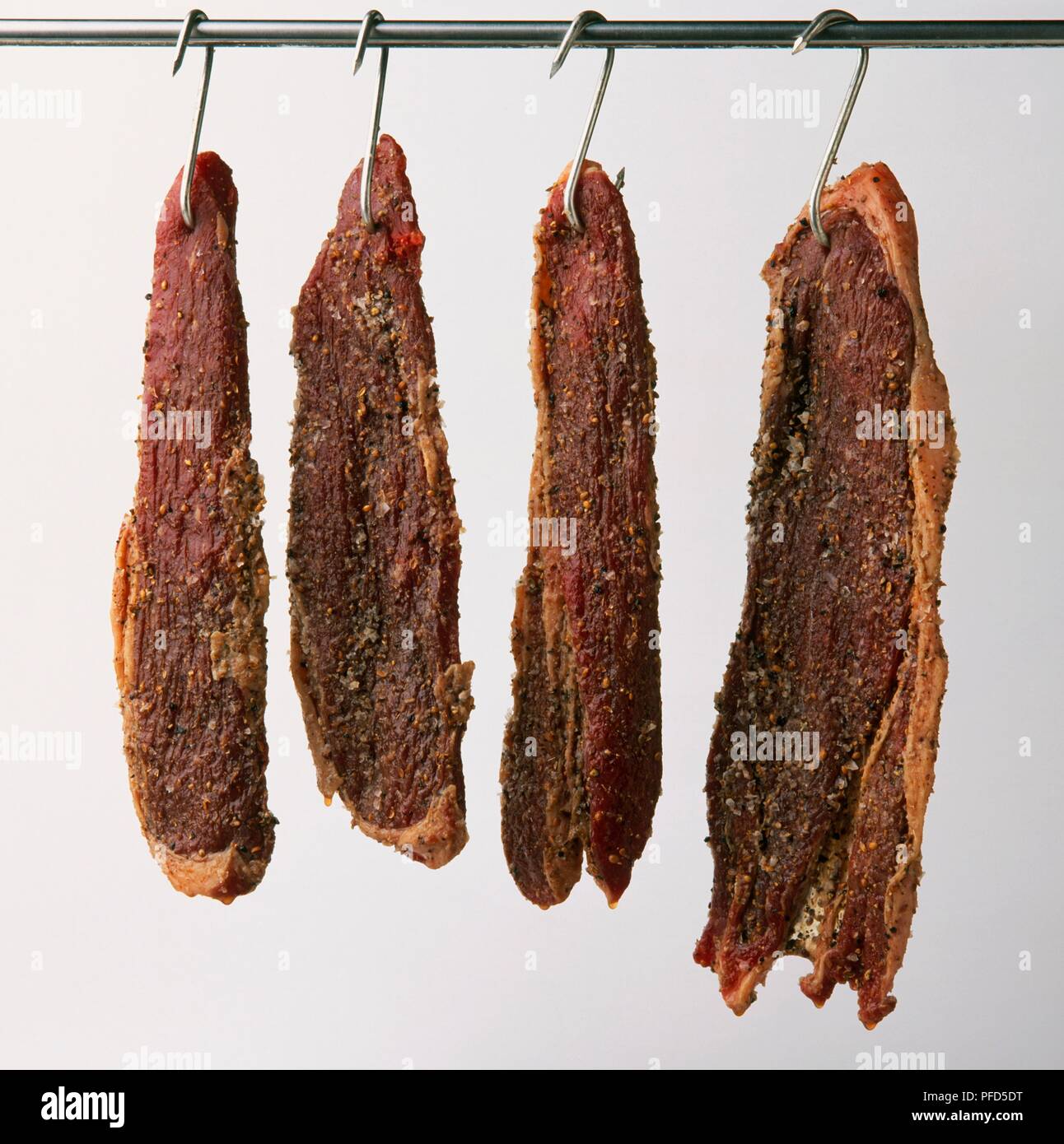 Fette di Biltong appeso su ganci Foto Stock