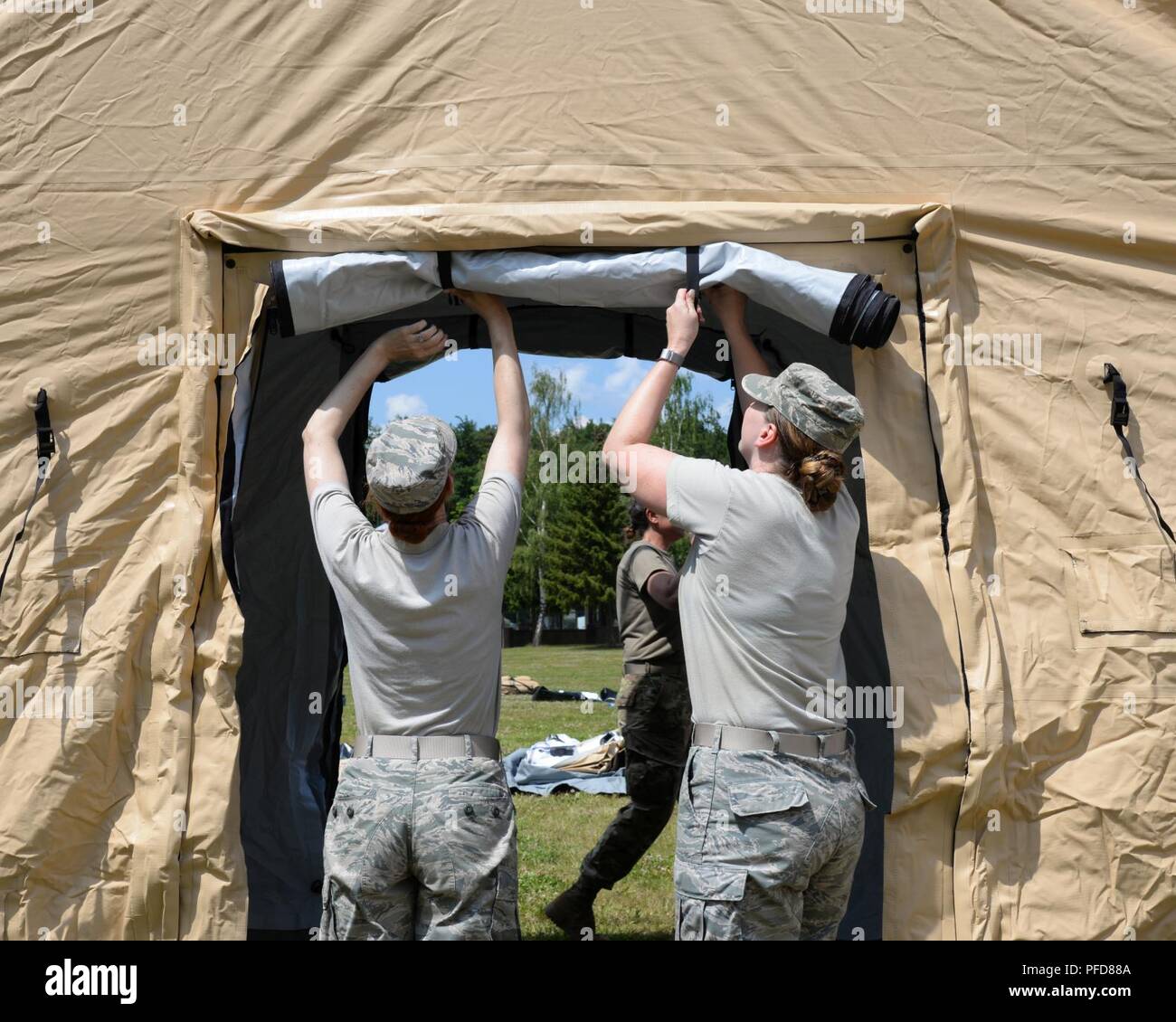 Avieri dal 86º Gruppo Medico, 86squadrone di logistica, croata e forze armate membri impostare Expeditionary Medical Support System tende per un en-route paziente sistema di staging durante l'esercizio Maroon Surge su Ramstein Air Base, Germania Giugno 4, 2018. I rifugi beneficiano di un innovativo sistema di distribuzione e può essere costruito in meno di cinque minuti. Foto Stock