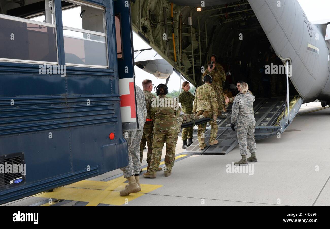 Stati Uniti Air Force, U.S. Esercito Croato e il personale medico a caricare un paziente su un C130J Super Hercules aeromobile durante la fase di esercizio Maroon Surge su Ramstein Air Base, Germania, 9 giugno 2018. Il personale medico a trasferire i pazienti dal specialmente attrezzati bus medica per gli aeromobili che devono essere trasportate per ulteriore trattamento. Foto Stock