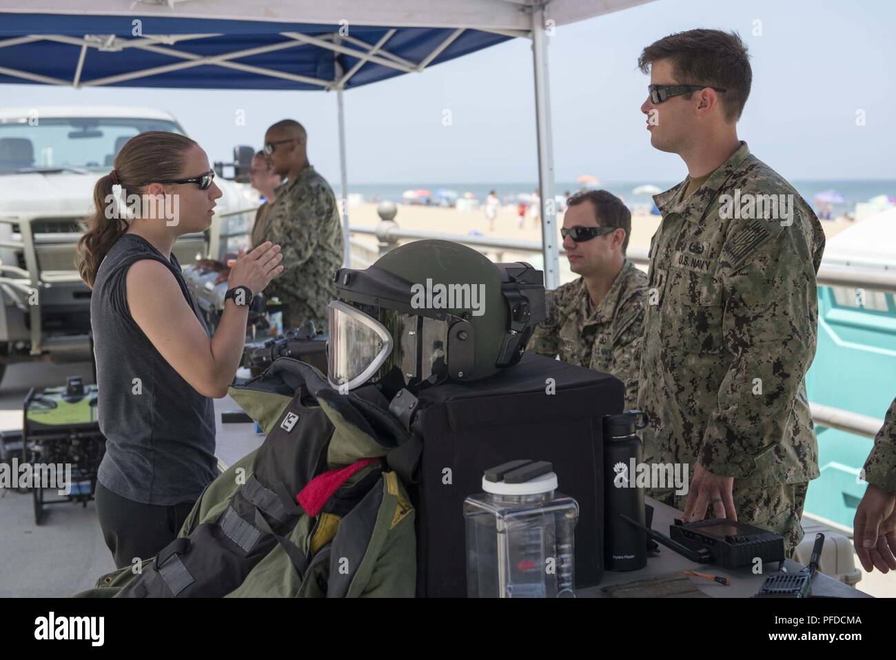VIRGINIA BEACH, Va. (1 giugno 2018) l'eliminazione degli ordigni esplosivi tecnici assegnati per l'eliminazione degli ordigni esplosivi gruppo (EODGRU) 2 parla con un visitatore all'uso militare durante il villaggio OSU Warrior settimana al lungomare di Virginia Beach. Settimana del guerriero, patrocinato dalla città di Virginia Beach e l'uso, è una sorta di evento per i feriti e ammalati e feriti di servizio e i membri delle loro famiglie. Foto Stock