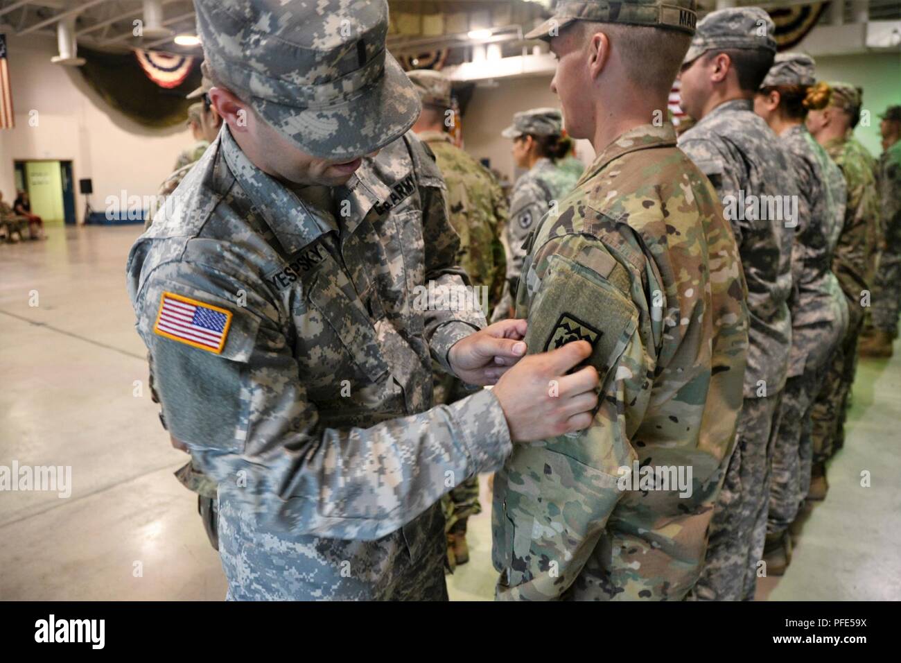 1Lt. Donald Yestrepsky, comandante della 2803rd Forward Support Company, Campo 109° Reggimento di Artiglieria, 55th manovra Brigata Enhancement, ventottesima divisione di fanteria, Pennsylvania Guardia Nazionale pone un campo 169a brigata di artiglieria patch sull'uniforme del PFC. Anthony Mauro durante il patching di una cerimonia di premiazione che si terrà a Fort Indiantown Gap 31 maggio 2018. Il 2803rd avanti la Società di assistenza fornisce il supporto per il campo 169a brigata di artiglieria. Foto Stock