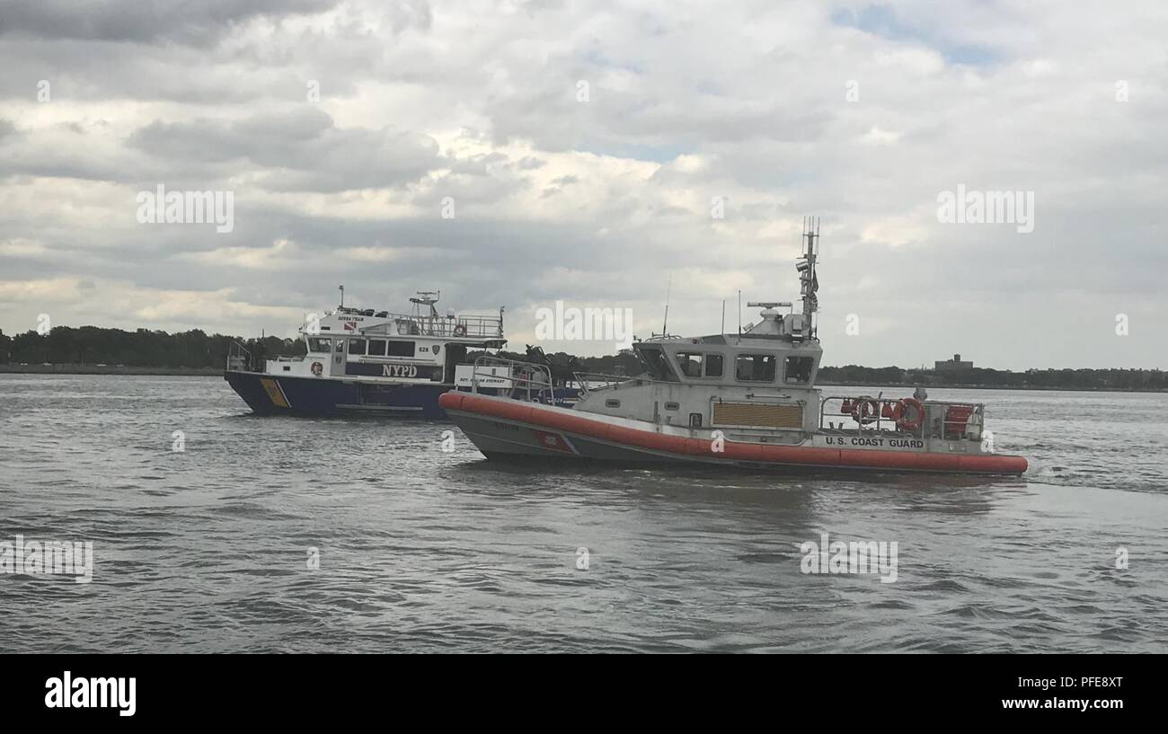 A New York il dipartimento di polizia in barca e una della Guardia Costiera degli Stati Uniti barca delimitare l'area dove i membri del New York La Guardia Nazionale di 24 armi di distruzione di massa civile del Team di supporto sono state conducendo training helocast vicino a Fort Hamilton, Brooklyn il 6 giugno 2018. New York milizia navale imbarcazione di pattuglia 440 prelevato i soldati e aviatori dopo aver praticato il salto da una New York Air National Guard elicottero in Gravesend Bay. ( Divisione di militari e gli affari navali Foto Stock