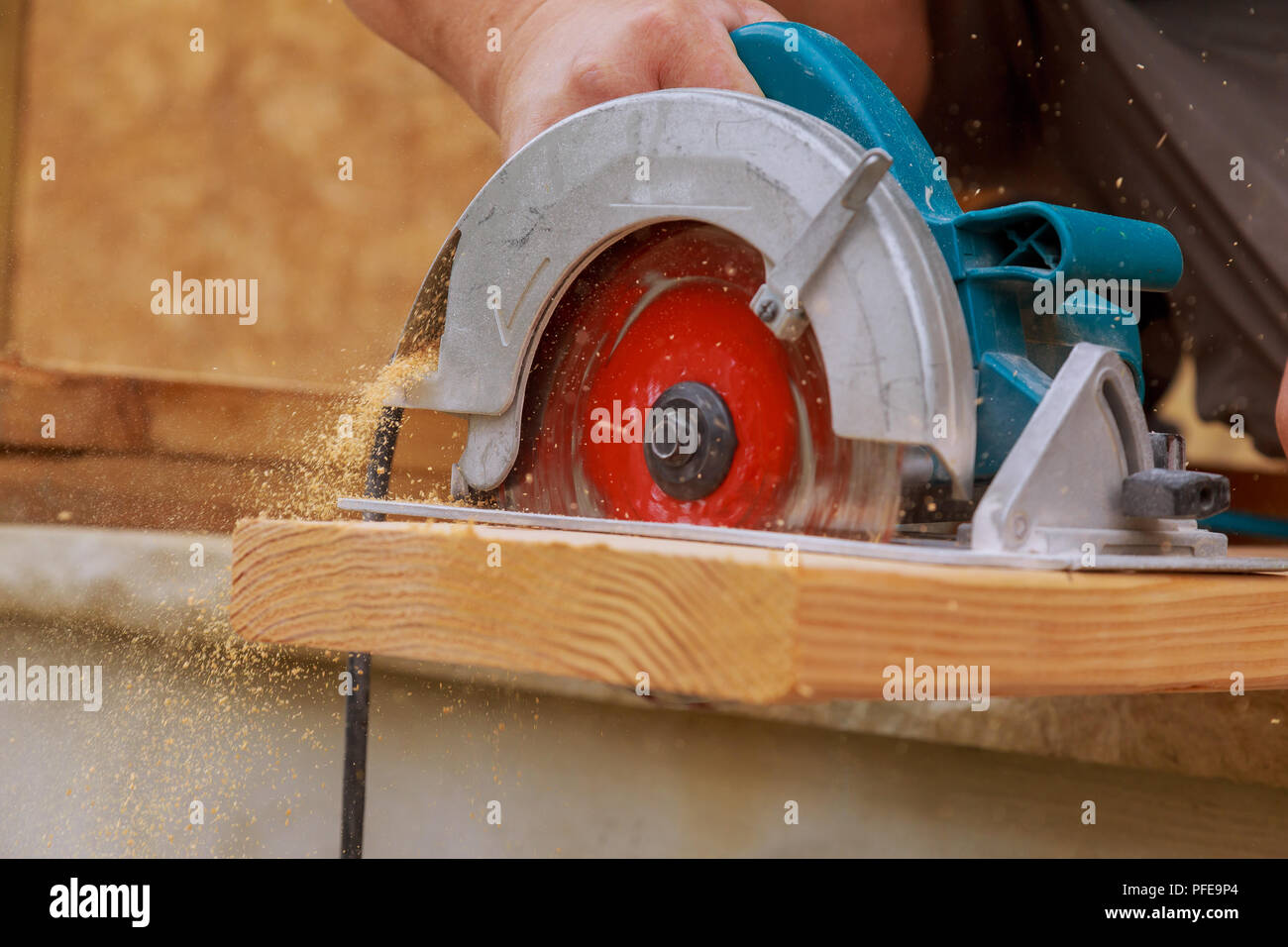 Nuovo home progetto constructiion imprenditore edile lavoratore utilizzando tenuto in mano unità worm sega circolare per il taglio di pannelli Foto Stock