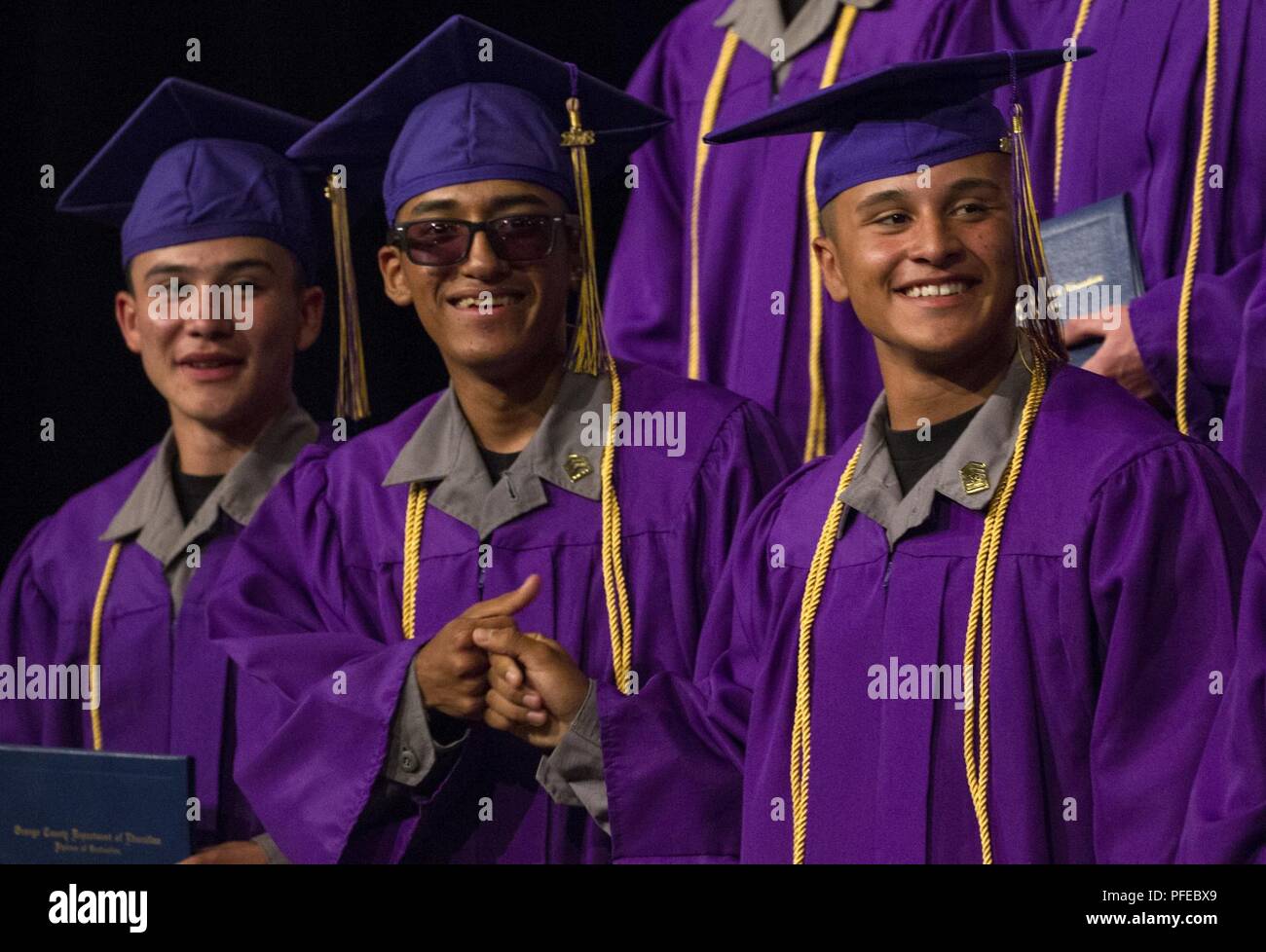 Sunburst sfida della gioventù Academy 21 classe Cadetti bump pugni dopo la ricezione del loro high school diplomi durante la classe inizio cerimonia, Giugno 9, 2018 a Los Alamitos, California. Più di 150 cadetti in accademia della ventunesima classe camminava sul palco a ricevere i certificati di completamento per il mese 5.5 fase residenziale del 17,5 mese Guardia Nazionale programma sfida. Fase residenziale laureati ora entrare in un yearlong fase di mentorship per terminare il programma. Foto Stock