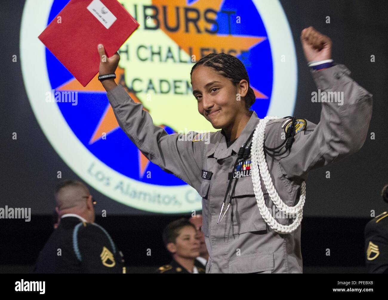 Sunburst sfida della gioventù Academy 21 classe Cadet Cruz si mette le mani in aria dopo aver ricevuto un certificato della zona residenziale di accademici e di completamento della fase durante la classe inizio cerimonia, Giugno 9, 2018 a Los Alamitos, California. Più di 150 cadetti in accademia della ventunesima classe camminava sul palco a ricevere i certificati di completamento per il mese 5.5 fase residenziale del 17,5 mese Guardia Nazionale programma sfida. Fase residenziale laureati ora entrare in un yearlong fase di mentorship per terminare il programma. Foto Stock
