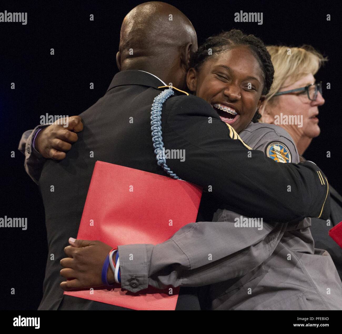 Sunburst sfida della gioventù Academy 21 classe Cadet Miyah Myles abbracci cadre degli stati e degli Stati Uniti Army Sgt. 1. Classe Timothy Edwards dopo aver ricevuto un certificato di completamento da la sfida del programma residenziale e fase accademica durante una cerimonia di inizio, Giugno 9, 2018 a Los Alamitos, California. Più di 150 cadetti in accademia della ventunesima classe camminava sul palco a ricevere i certificati di completamento per il mese 5.5 fase residenziale del 17,5 mese Guardia Nazionale programma sfida. Fase residenziale laureati ora entrare in un yearlong fase di mentorship per terminare il programma. Foto Stock