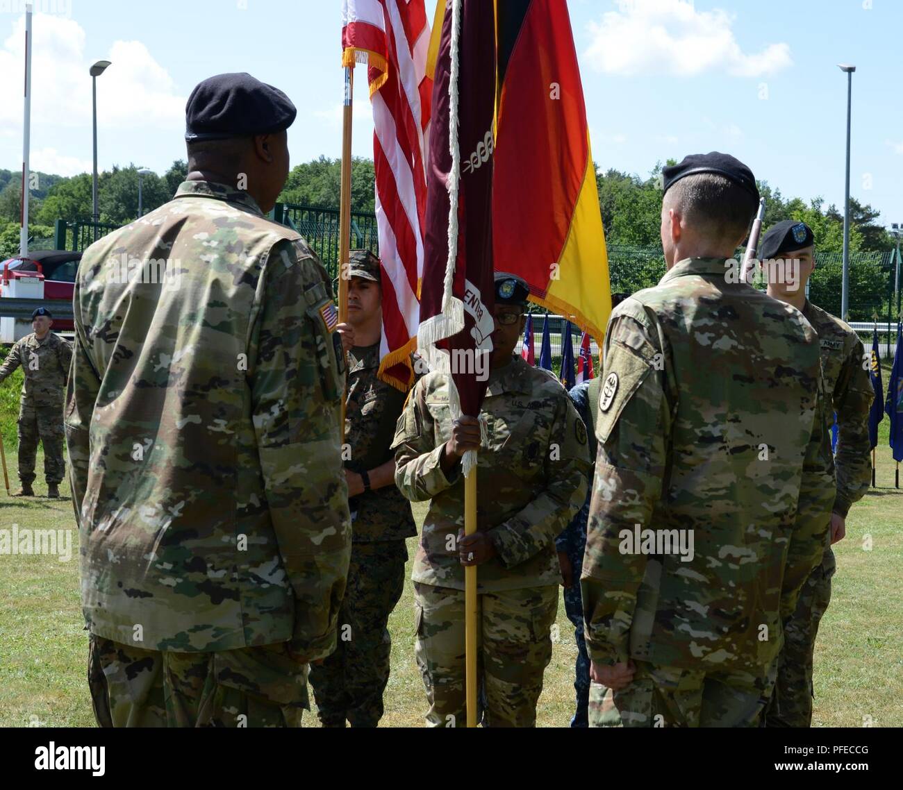 Stati Uniti Army Sgt. Prima Classe Cheryl Mays (centro), Landstuhl Regional Medical Center (LRMC) colore colori di guardia sergente, si prepara a mano i colori dell'ospedale al comando Sgt. Il Mag. Clark Charpentier (a destra) durante la sua rinuncia di responsabilità cerimonia tenutasi il 30 maggio 2018 a Landstuhl/Germania Foto Stock