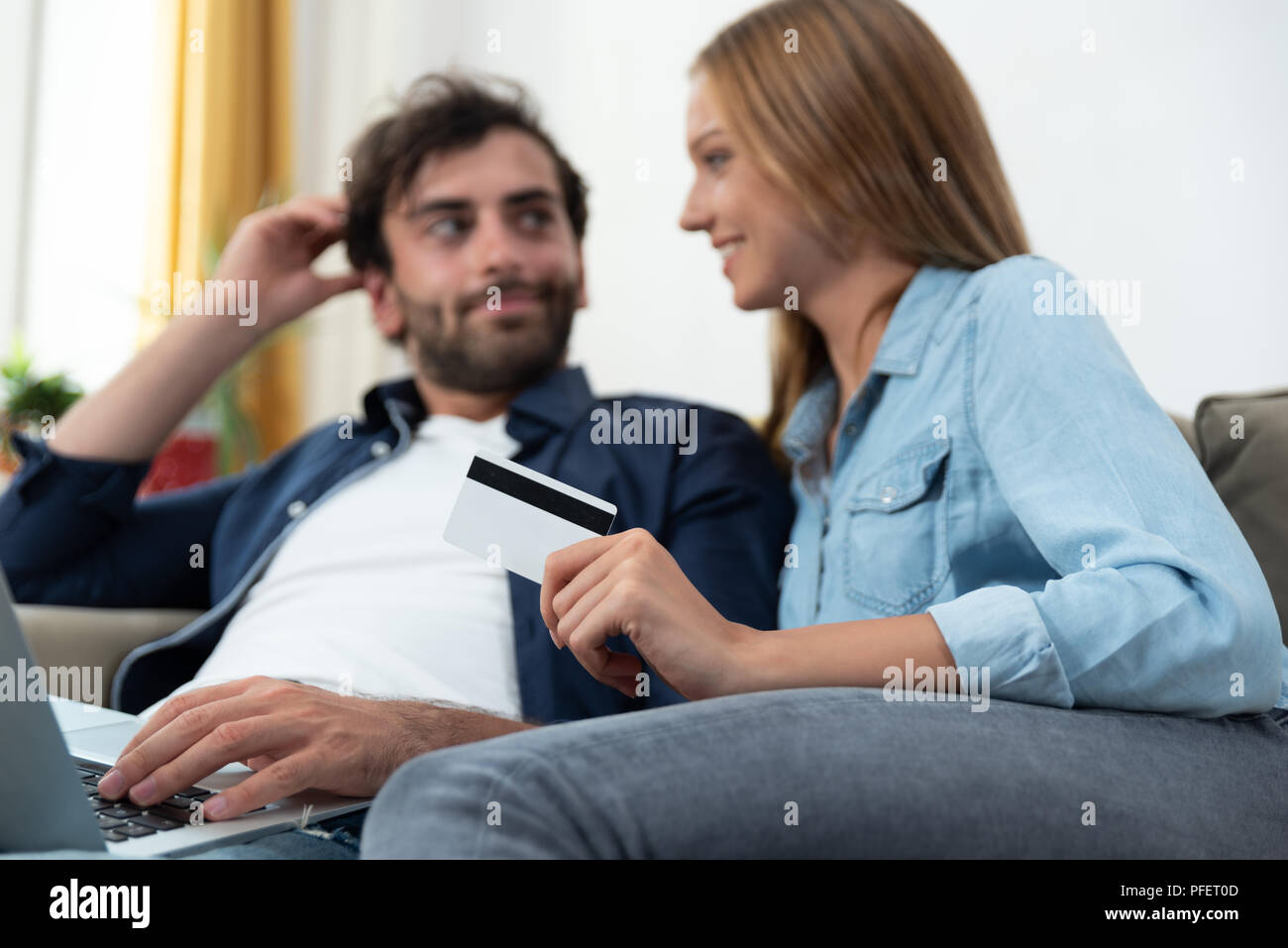 Coppia giovane facendo shopping online in internet e utilizzando una carta di credito Foto Stock