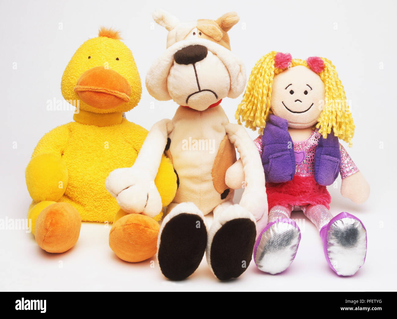 Tre morbidi giocattoli, anatra, cane e rag doll. Foto Stock