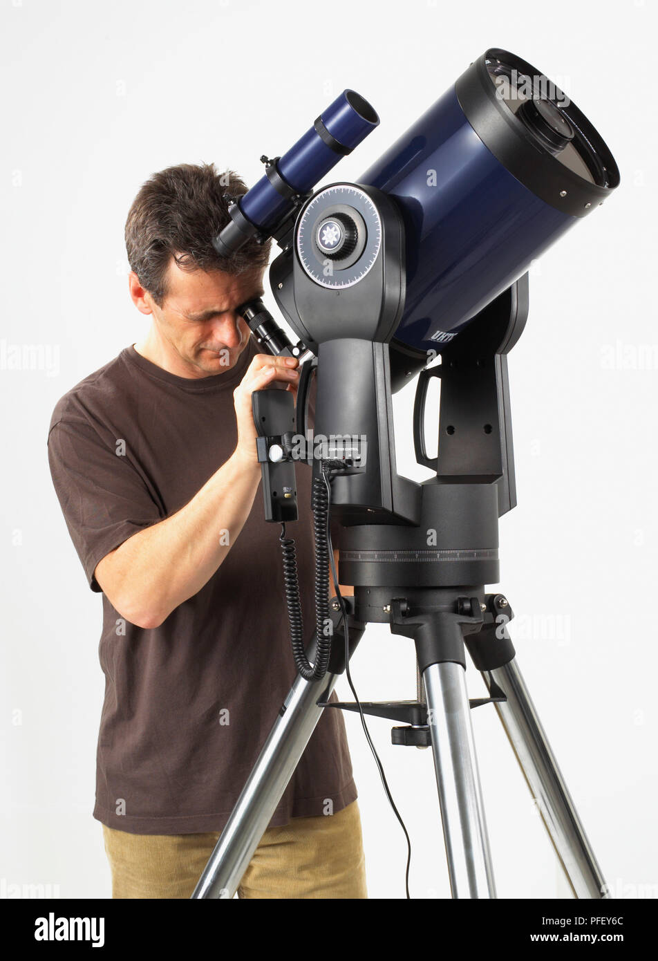 Uomo che guarda attraverso il telescopio catadiottrico Foto Stock