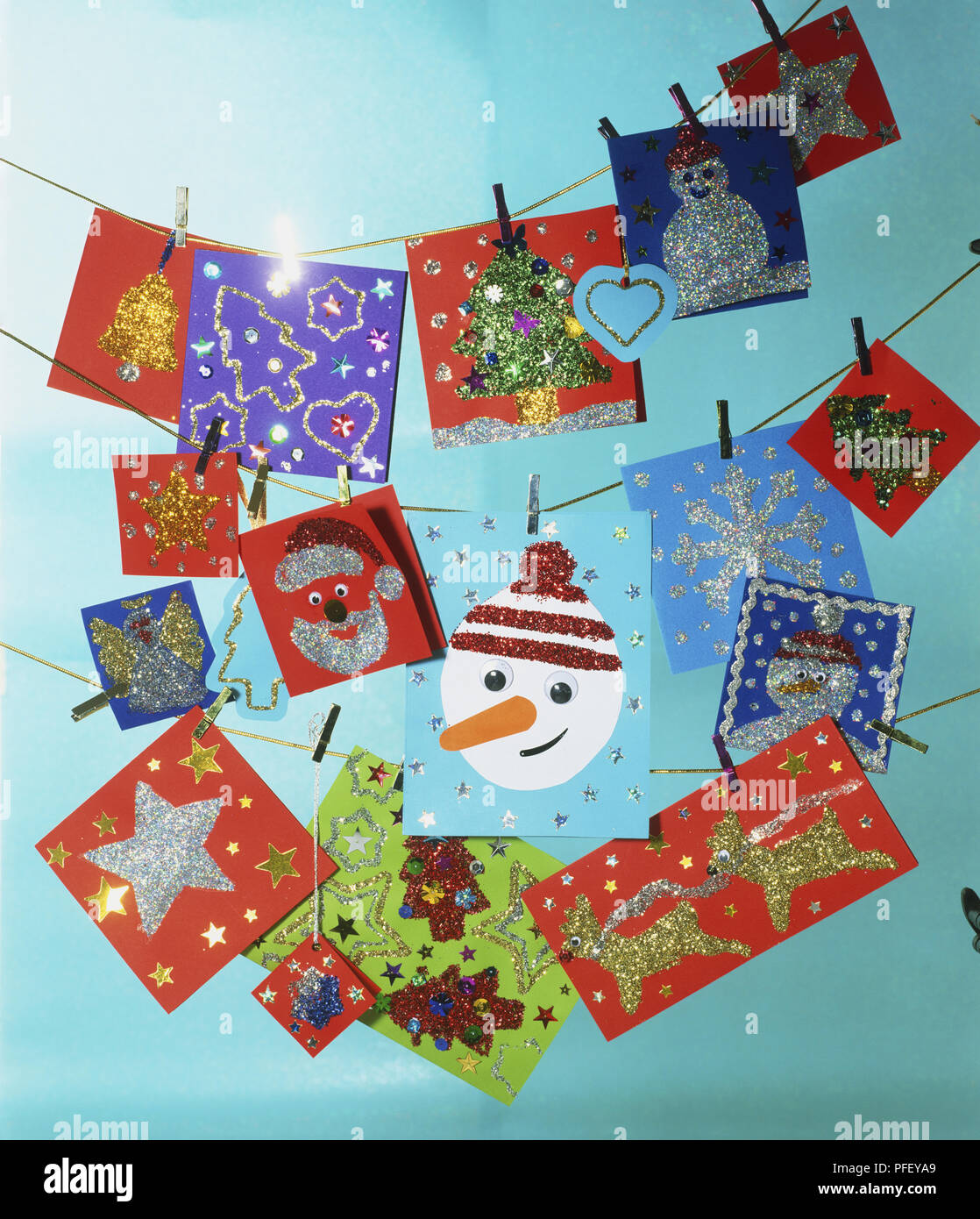 Una selezione di glittery Carte di Natale appesi da linee, attaccato con mollette Foto Stock
