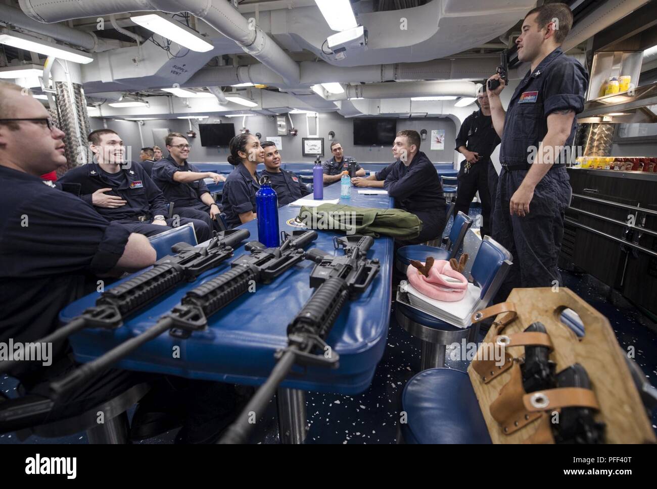 Mare delle Filippine (13 giugno 2018) da bombardieri Mate 2a classe Nathan Barnes, destro da Genesee, Idaho, dà il braccio piccolo armi familiarizzazione formazione oltre la M9 pistola di servizio per i marinai a bordo del Arleigh Burke-class guidato-missile destroyer USS Benfold (DDG 65). Benfold è distribuita negli Stati Uniti 7 flotta area di operazioni a sostegno della sicurezza e della stabilità nella regione Indo-Pacifico. Foto Stock