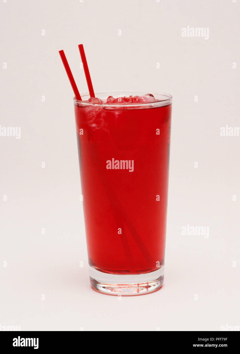 Bicchiere di colore rosso bere e ghiaccio, due cannucce di rosso. Foto Stock