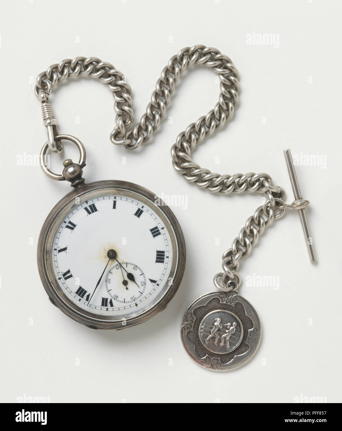 Orologio da tasca con numeri romani, chunky catena d'argento, medaglia d'argento che mostra due pugili attaccato all'altra estremità Foto Stock