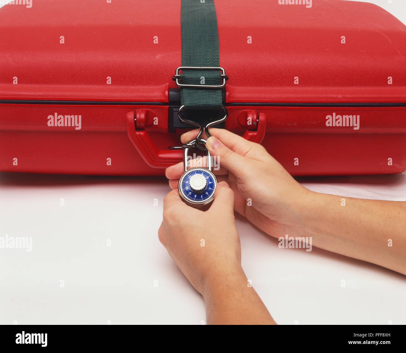 Rosso valigia in plastica essendo bloccato con serratura a combinazione, vista frontale. Foto Stock