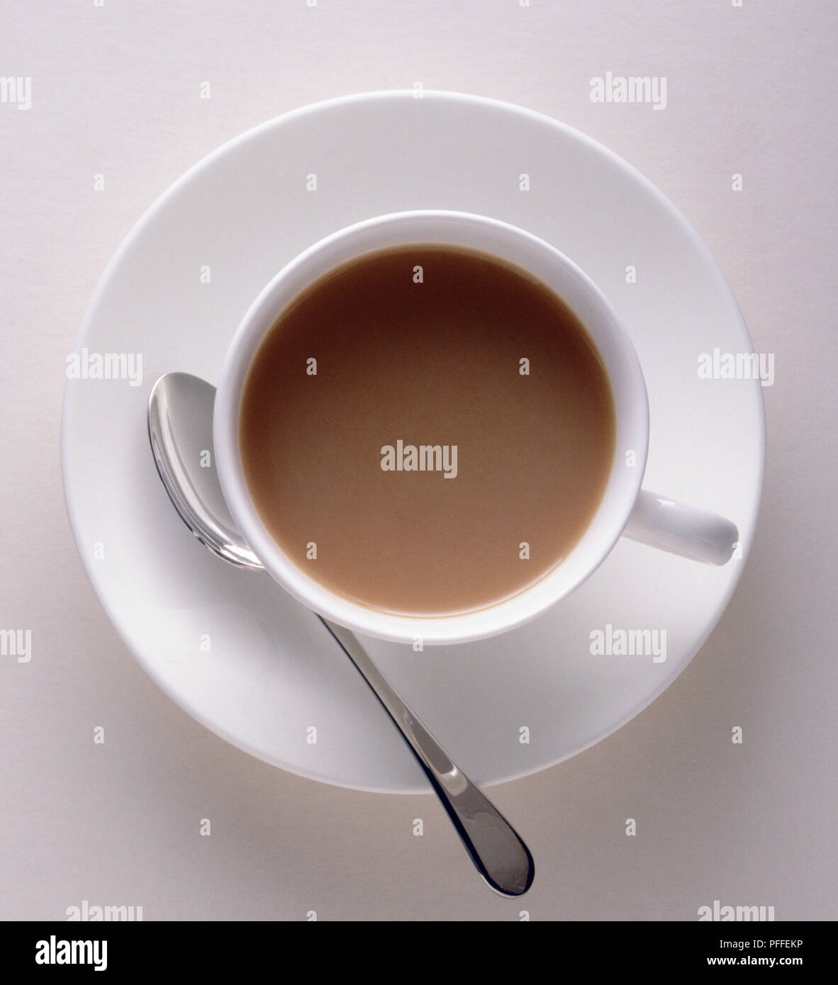 Tazza di Tè con latte, piattino cucchiaio, vista da sopra Foto Stock