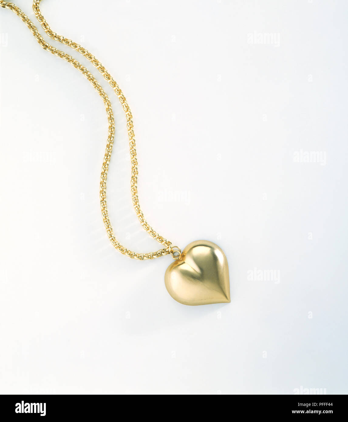 Oro ciondolo a forma di cuore su una catena in oro Foto Stock