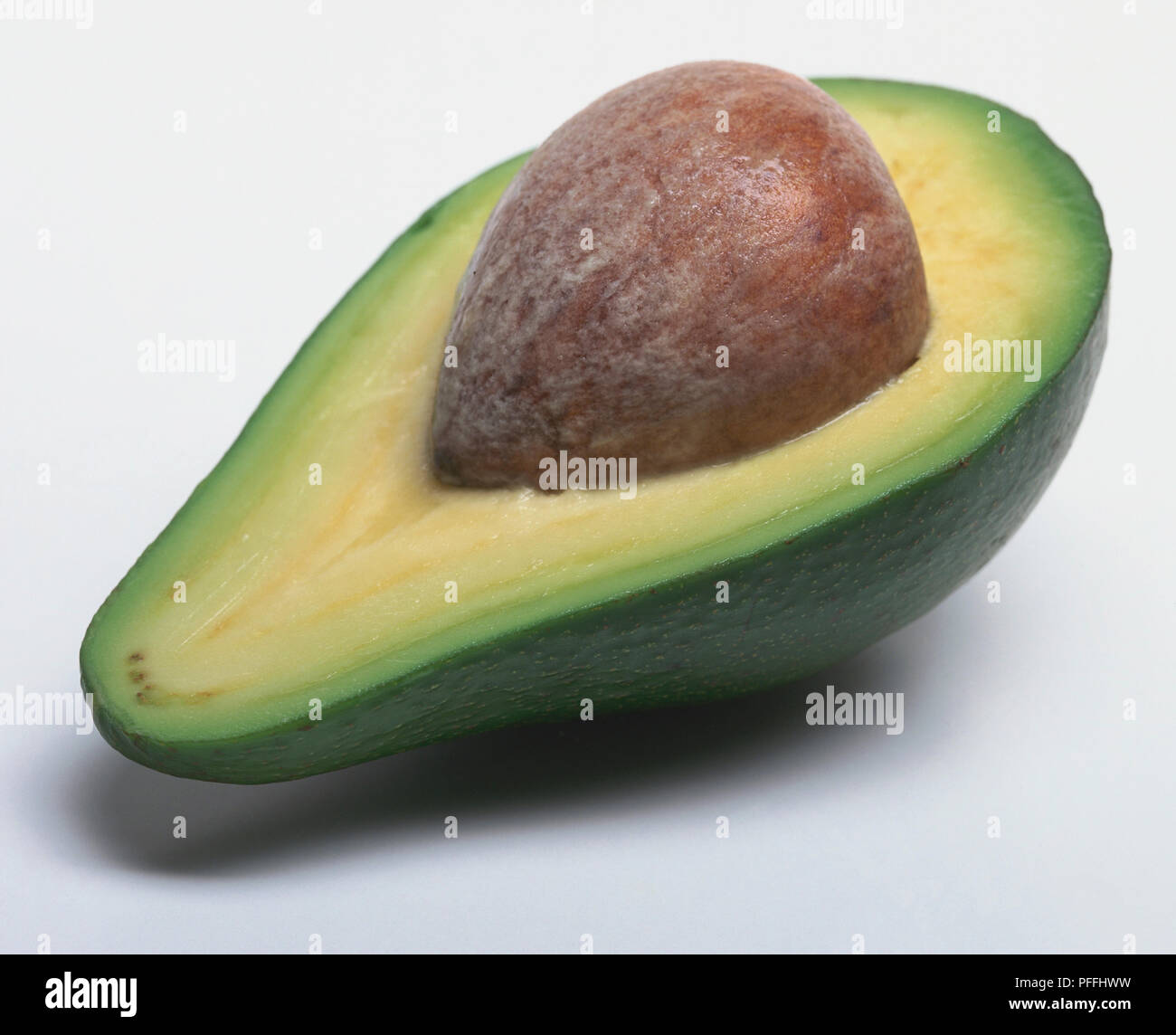 Dimezzato coltivate con metodo biologico di pere di avocado con pietra ancora all'interno. Foto Stock