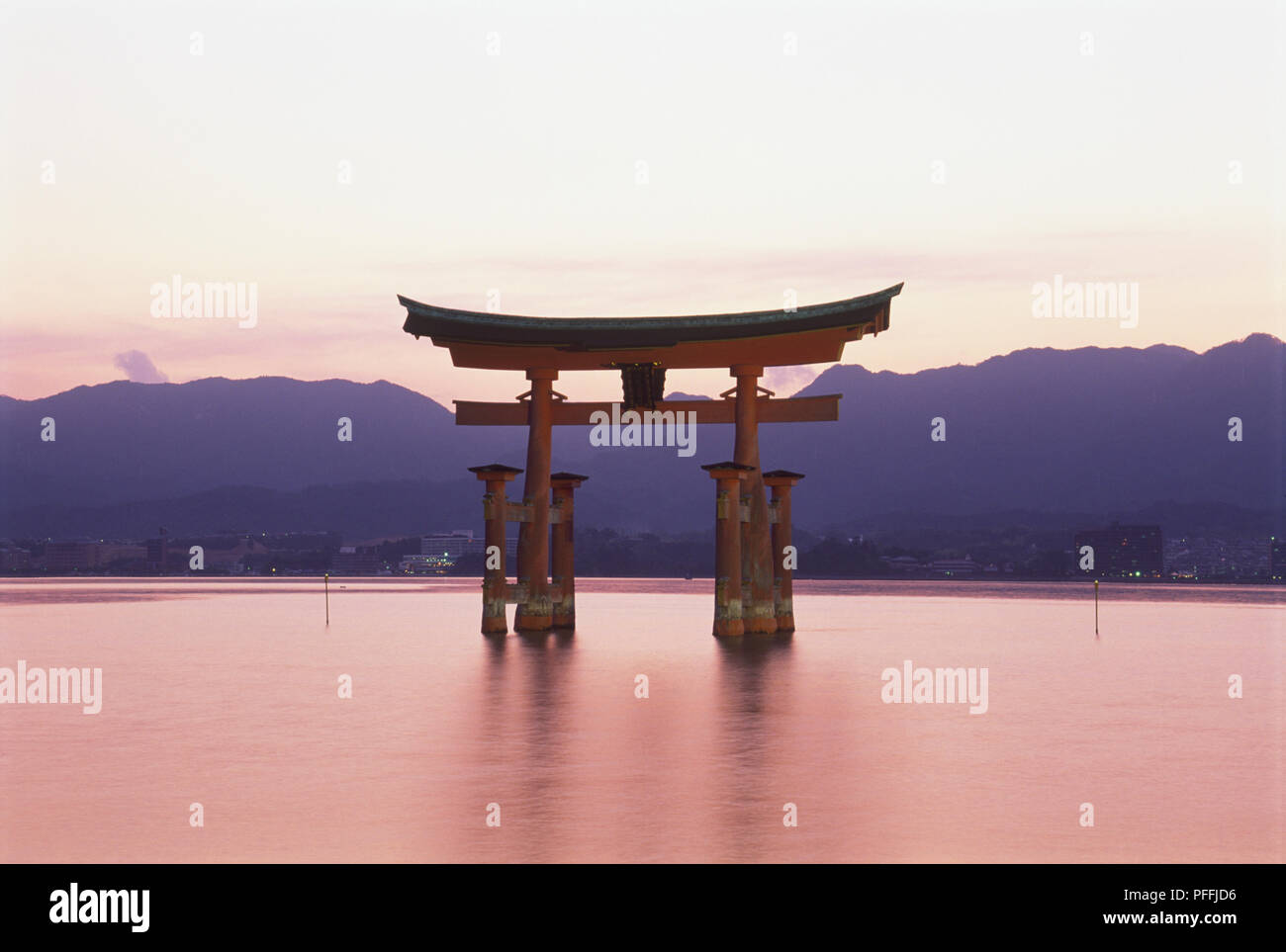 Giappone, Western Honshu, l'isola di Miyajima, santuario di Itsukushima, floating gate (Torii) al tramonto. Foto Stock