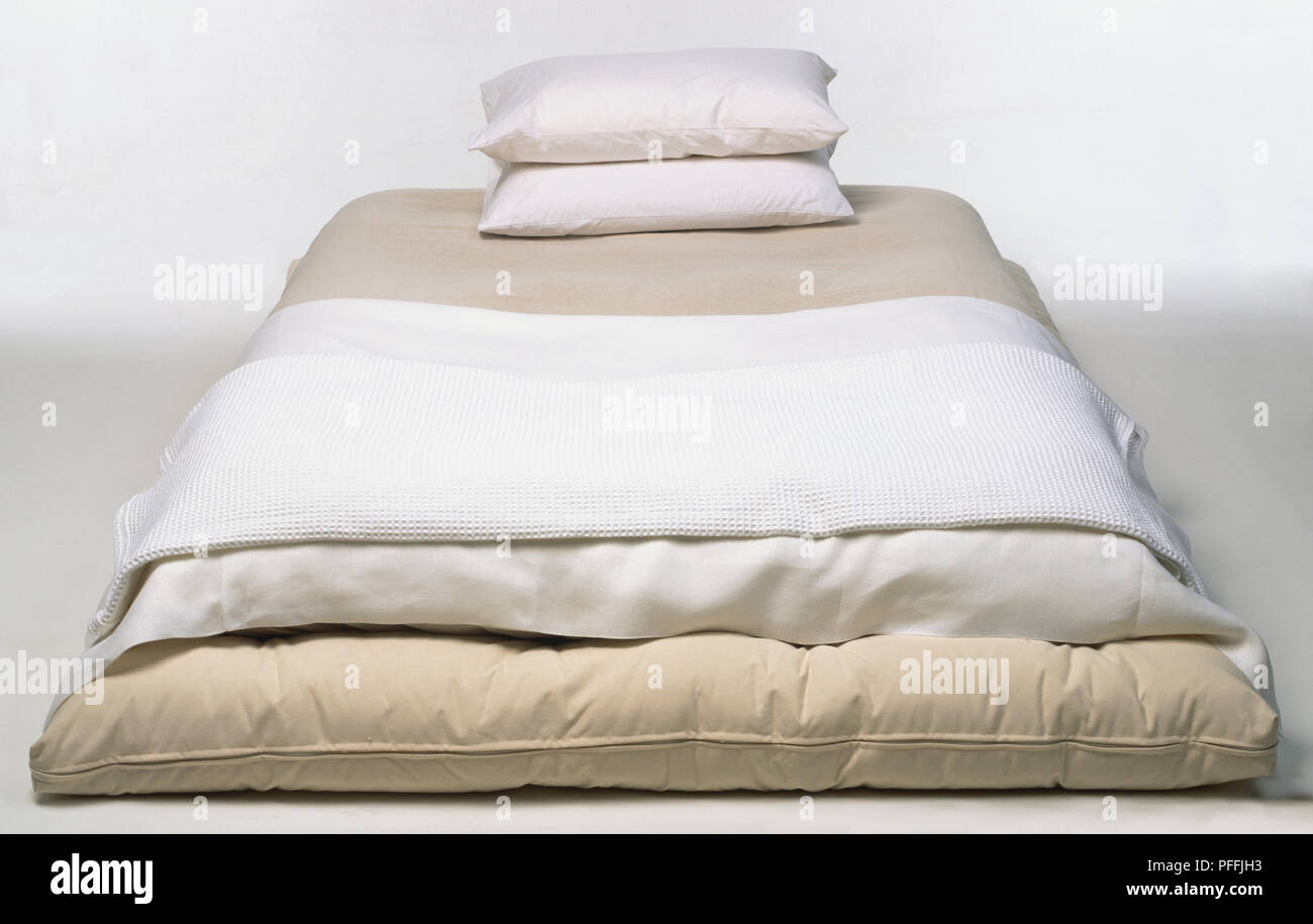 Futon singolo, due cuscini impilati, coperto con lenzuola bianche Foto  stock - Alamy