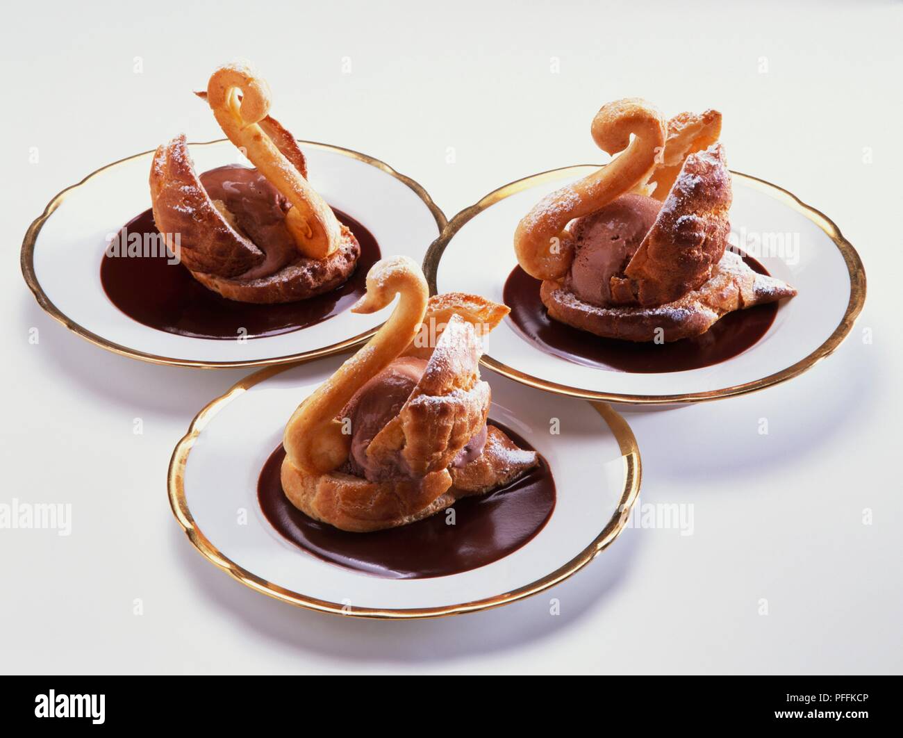 Tre profiteroles riempito con gelato al cioccolato e realizzato in forma di  cigno Foto stock - Alamy
