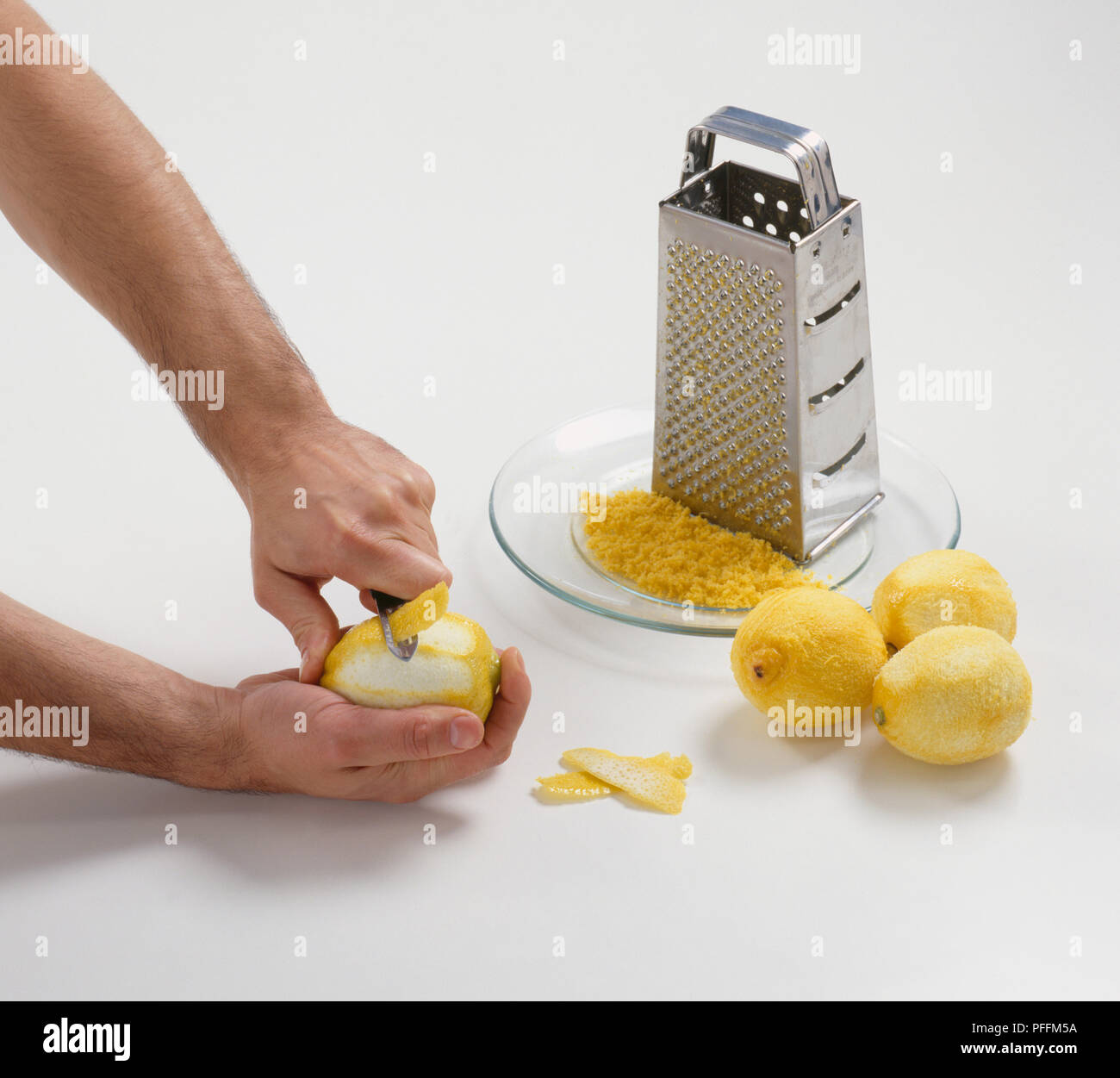 Mani con sbucciatore per striscia off la scorza di un limone, con Sbucciate  i limoni, grattugia