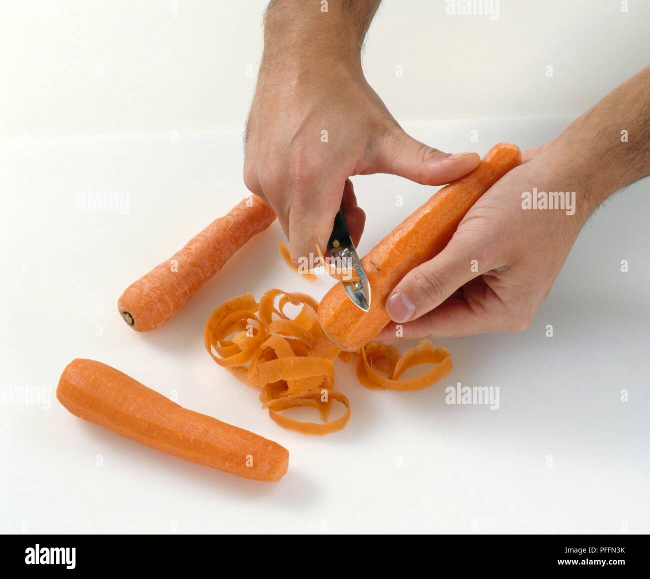 Pelare le carote con il pelapatate Foto Stock