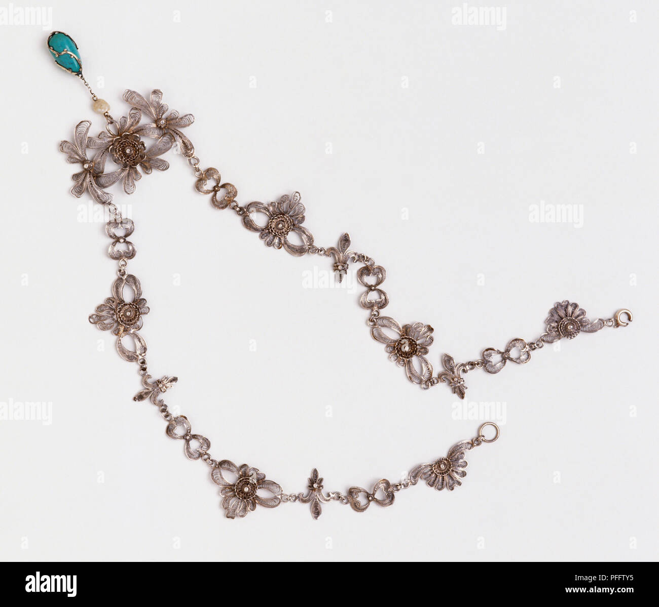 Collana in argento con fiore-elementi sagomati e turquiose pendente, vicino. Foto Stock