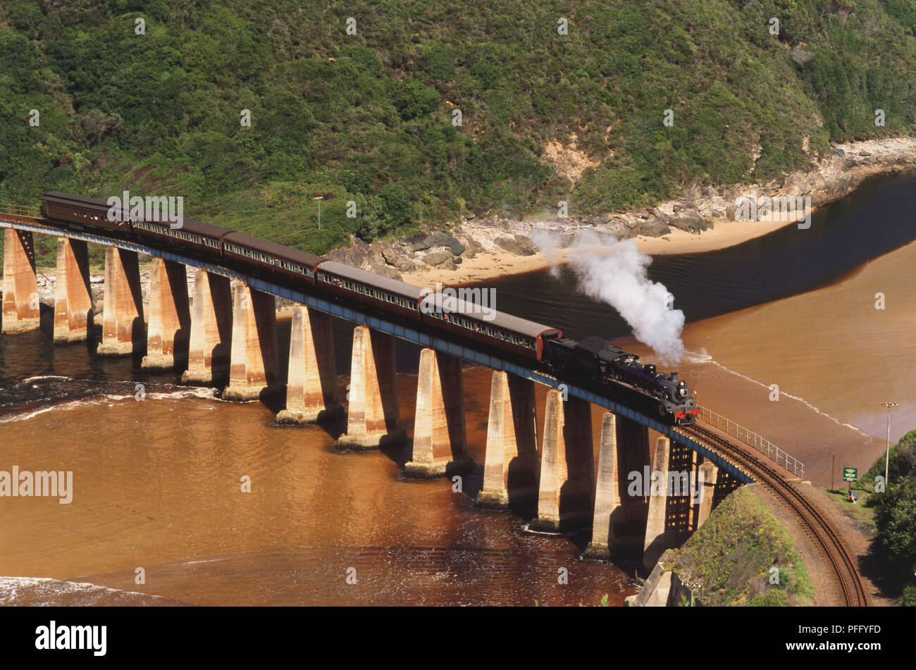 Il treno Choo-Tjoe attraversando Kaaimans River Bridge, il quale è supportato da enormi colonne di cemento. Foto Stock