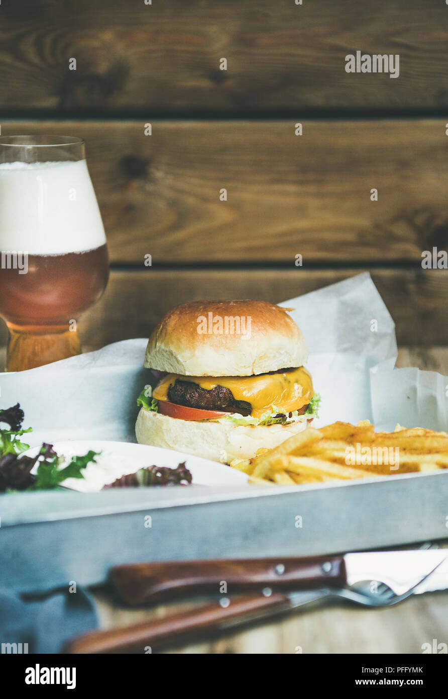 Classica cena hamburger con patatine fritte, insalata e birra Foto Stock