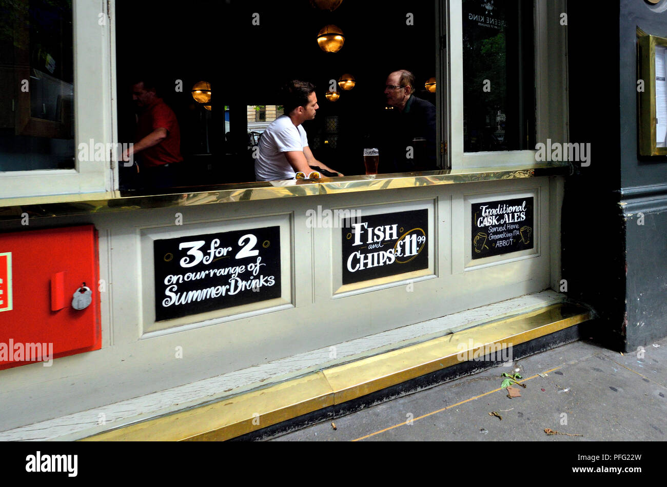 La gente alla finestra aperta del Garrick Arms pub in Charing Cross Road, Londra, Inghilterra, Regno Unito. Foto Stock